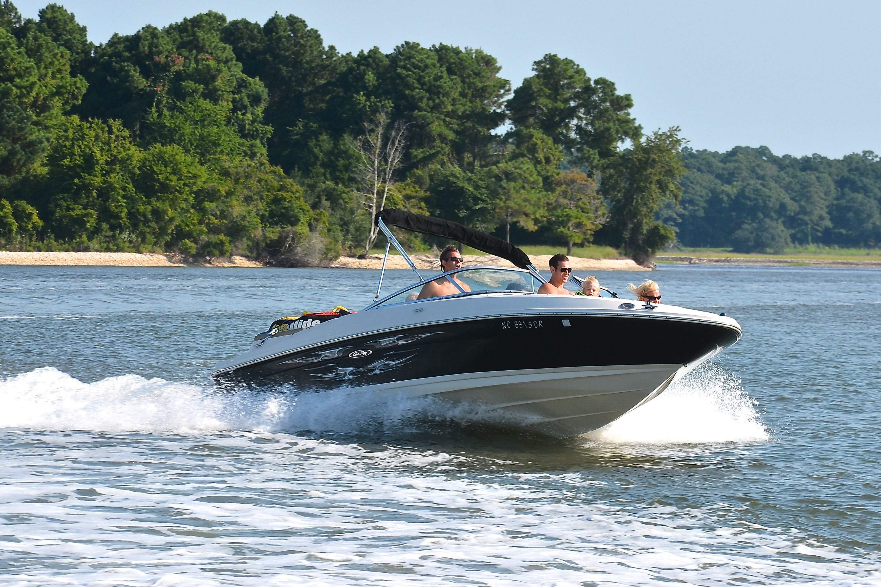 A high angle shot of a family riding a bowrider boat while cruising on a lake.