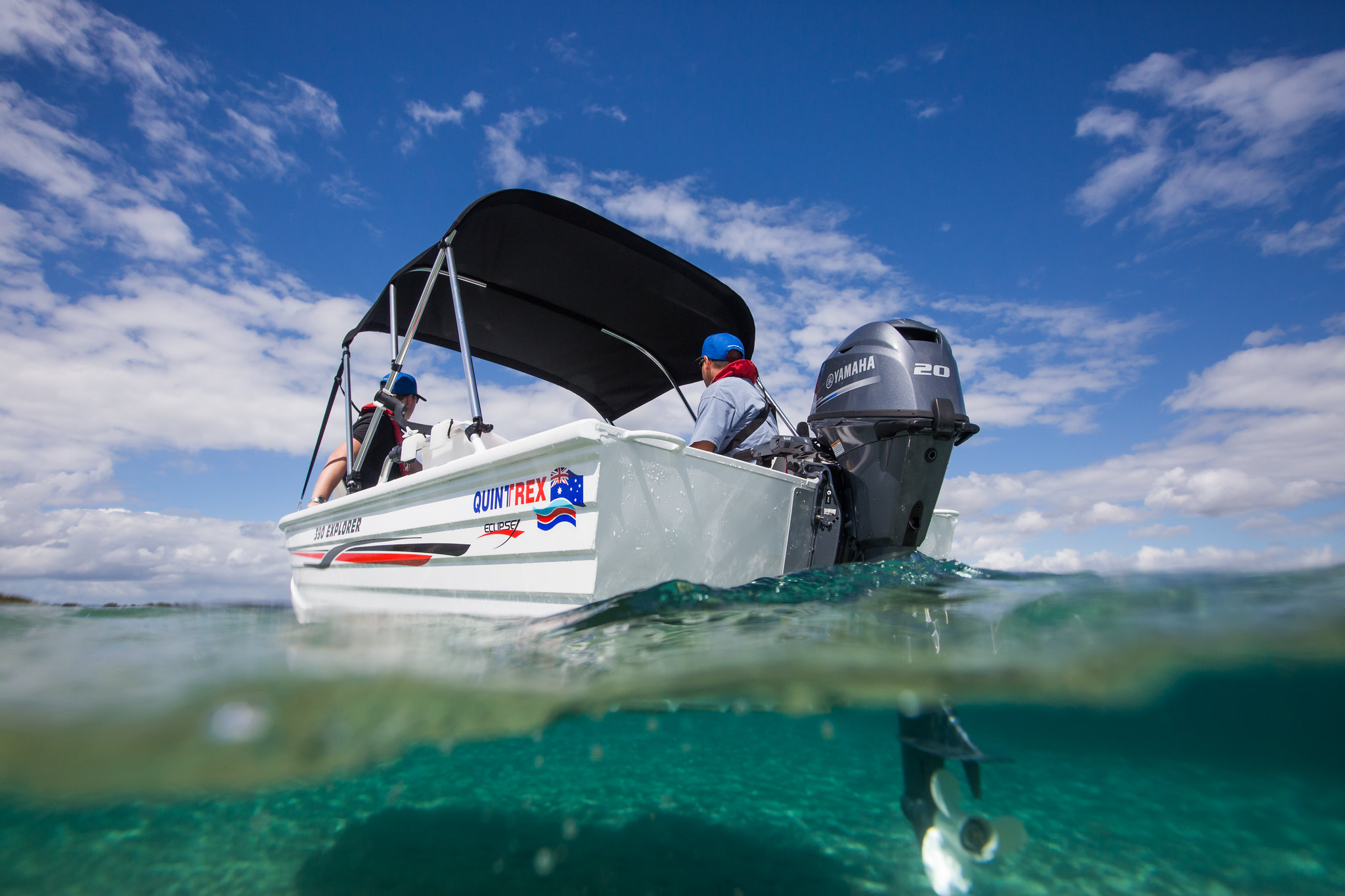 A low angle shot of a Quintrex Explorer, an inshore boat, with two boaters onboard.