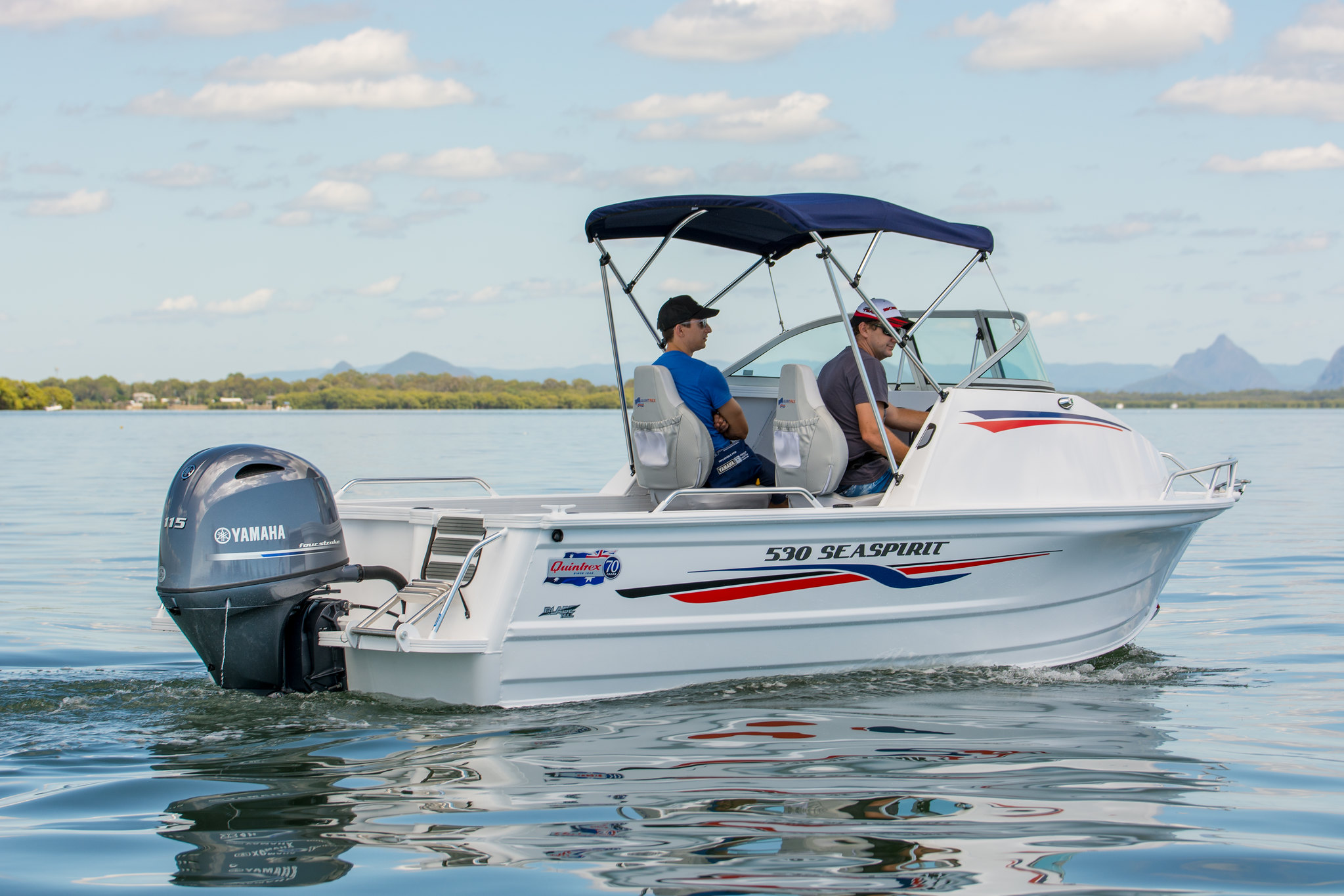 Two men aboard a small Quintrex boat.