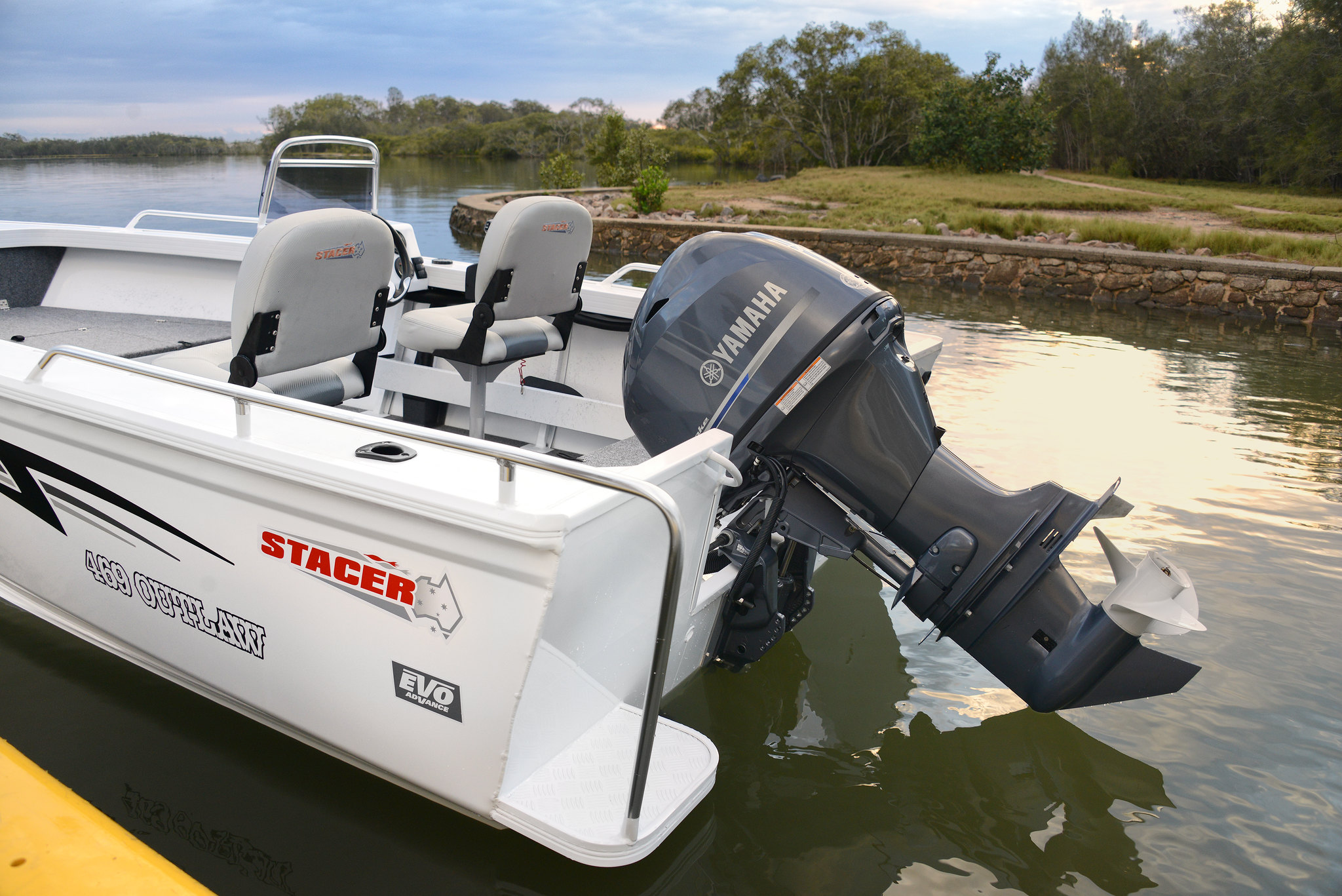 A Stacer boat with a Yamaha outboard motor docked at a lakeside dock.