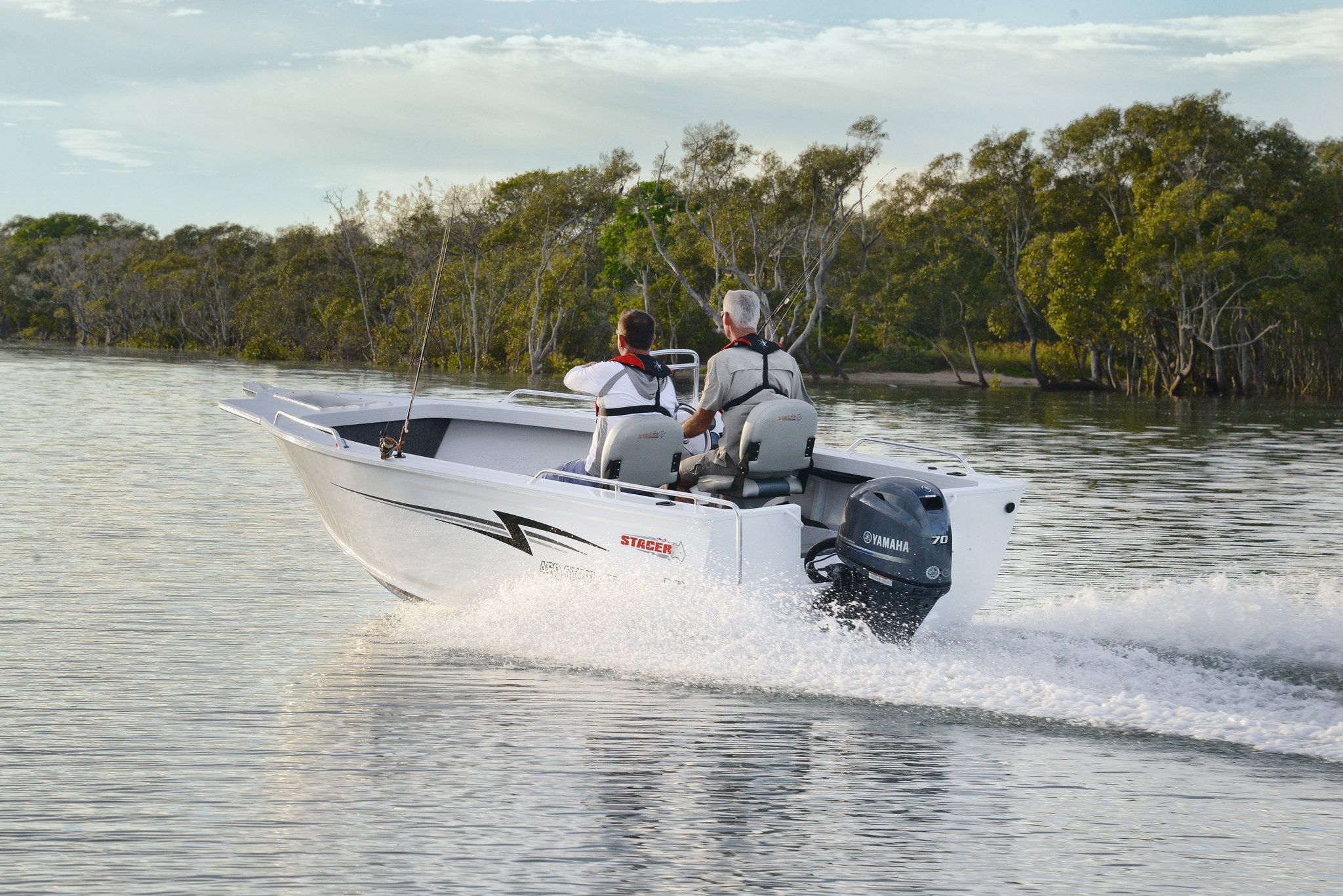 Two men riding a Stacer boat while underway.