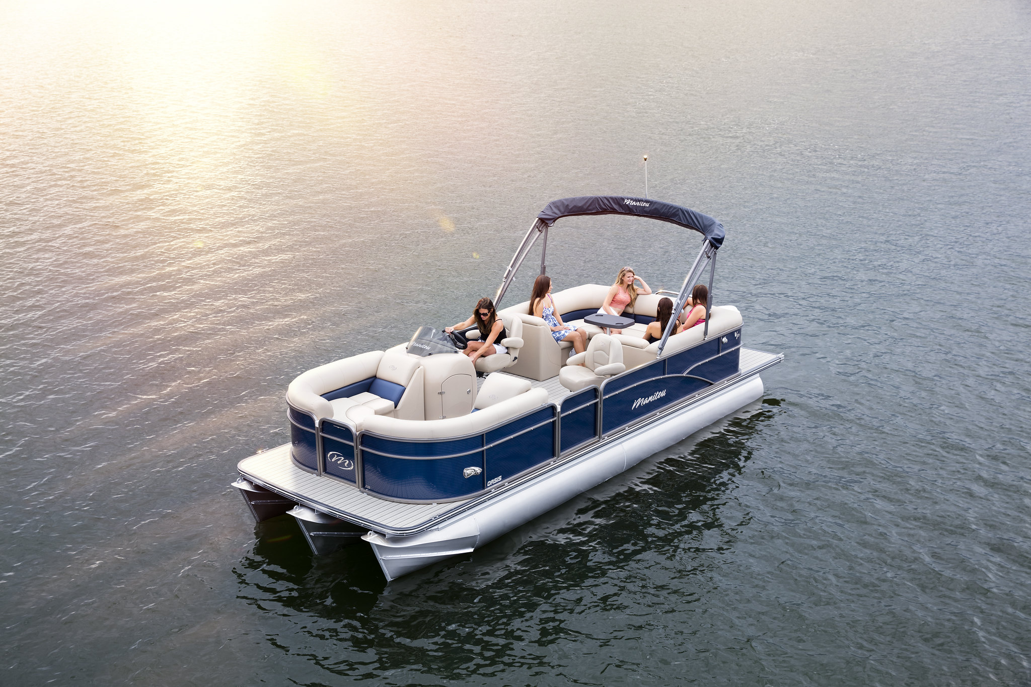 A group of people aboard a Manitou pontoon.