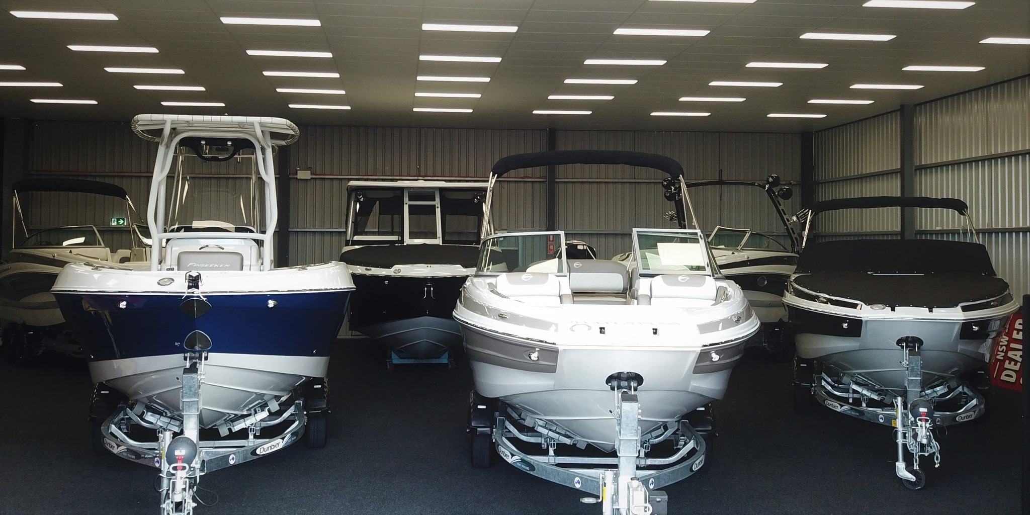 A row of Crowline boats displayed in a showroom.