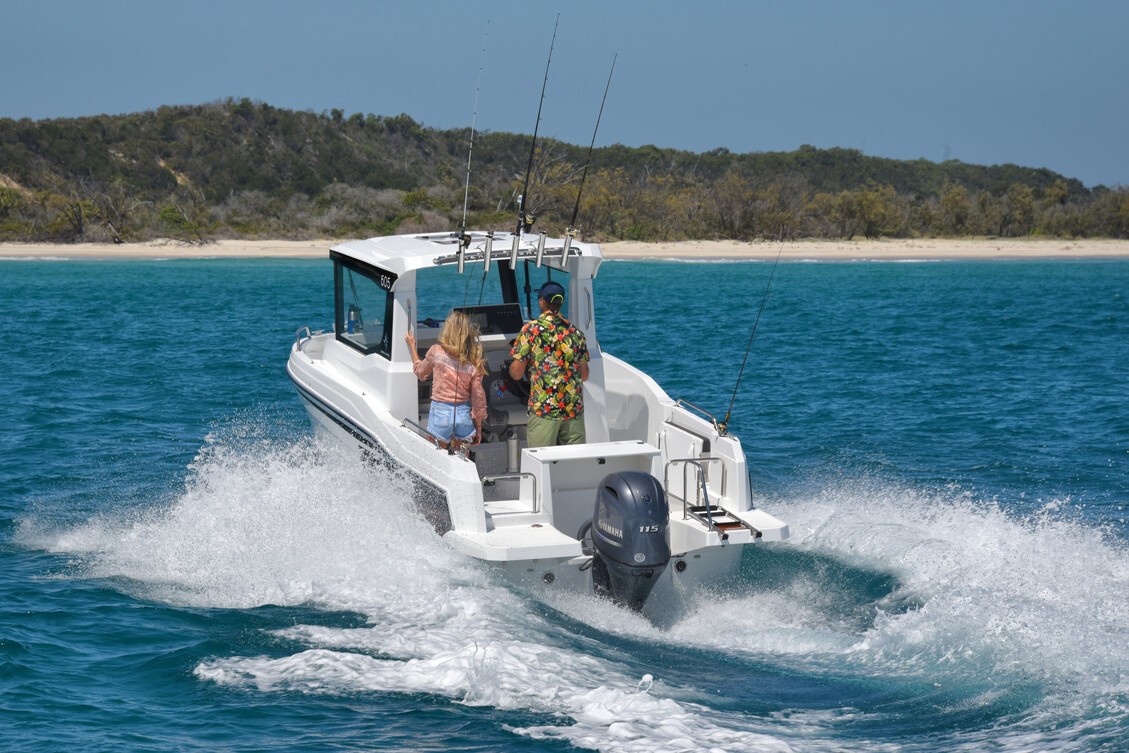 A family onboard a hard top boat running at full speed at sea.