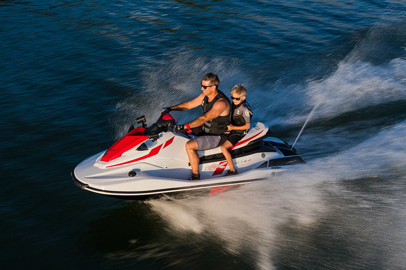 A man riding a PWC with kid