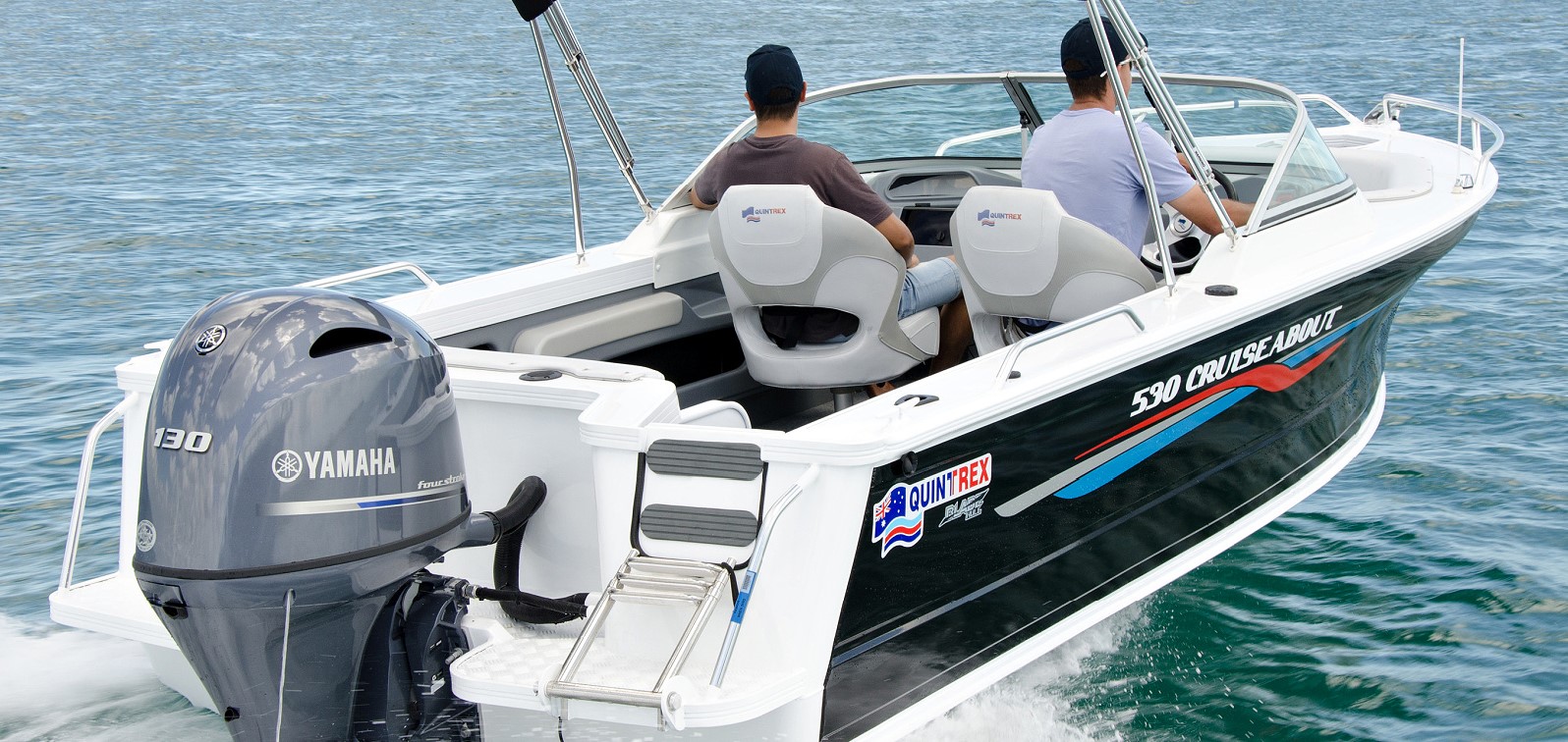 A view of a Quintrex boat's transom with an outboard motor attached on it while two men are operating the boat.