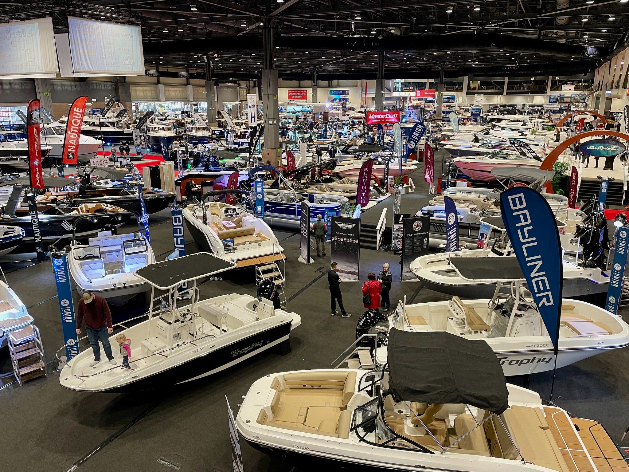 A high angle shot of a wide display of boats from various brands in a boat show.