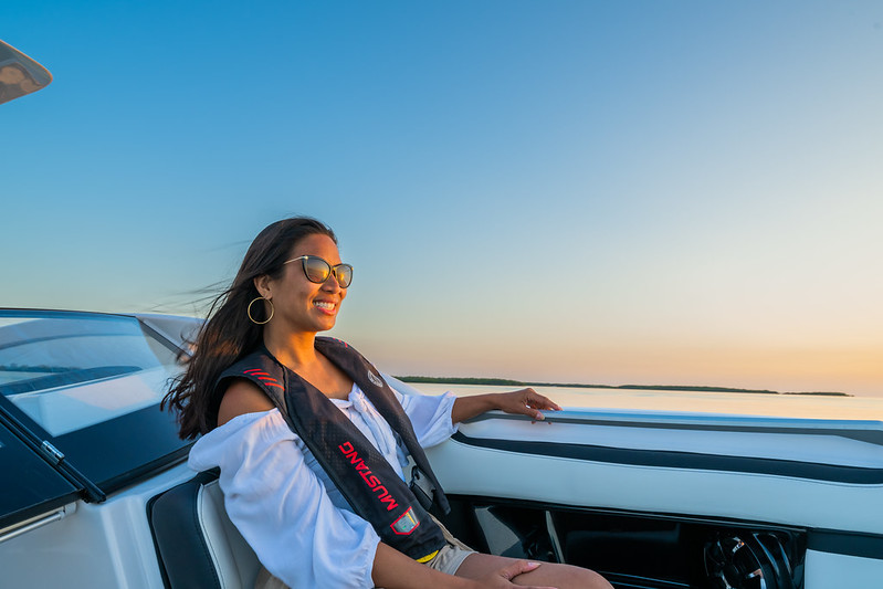 A woman sitting smiling on a boat.