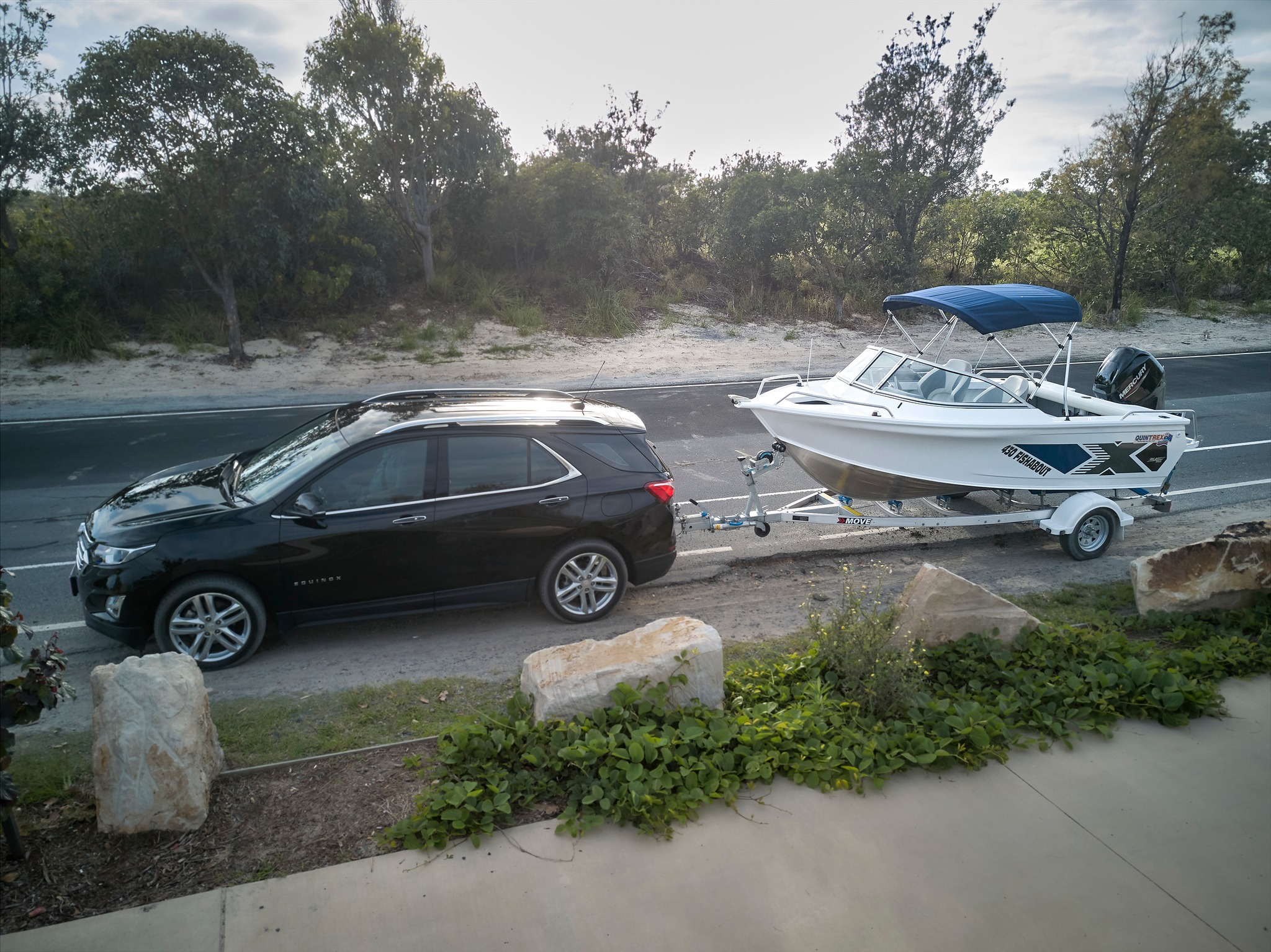 A vehicle towing a boat and a trailer.