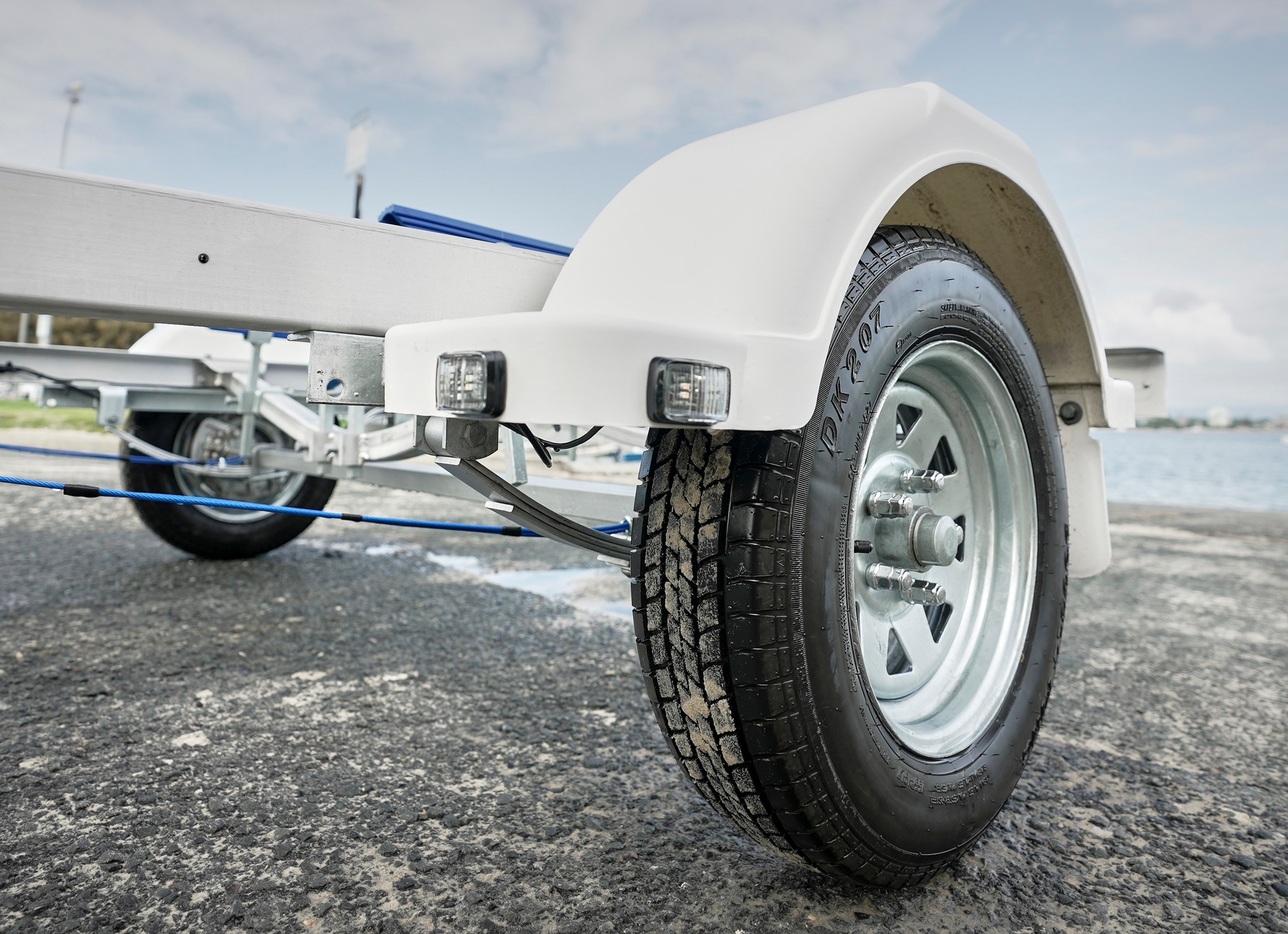 A close up shot of a boat trailer wheel.