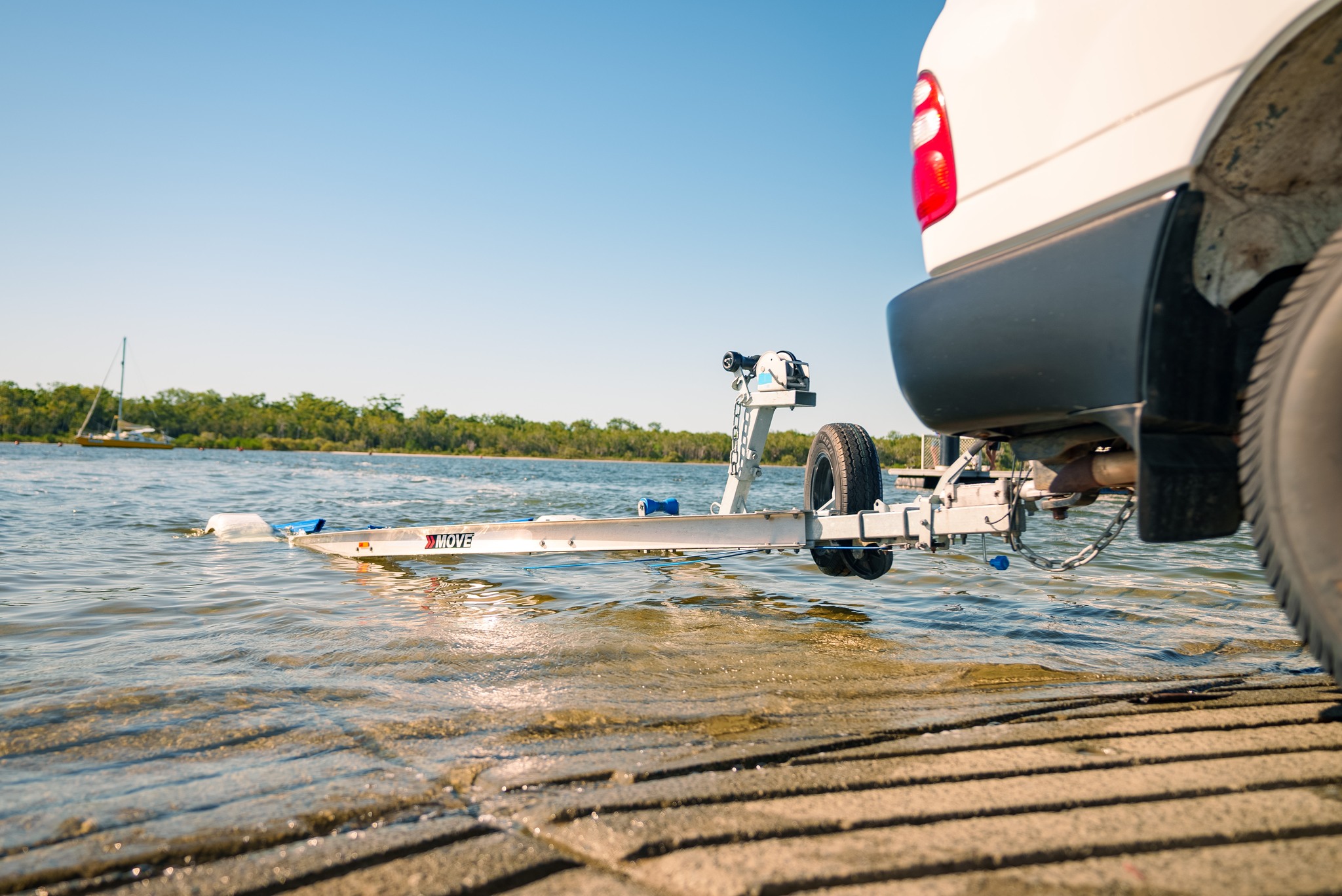 A boat trailer being launched in the water.