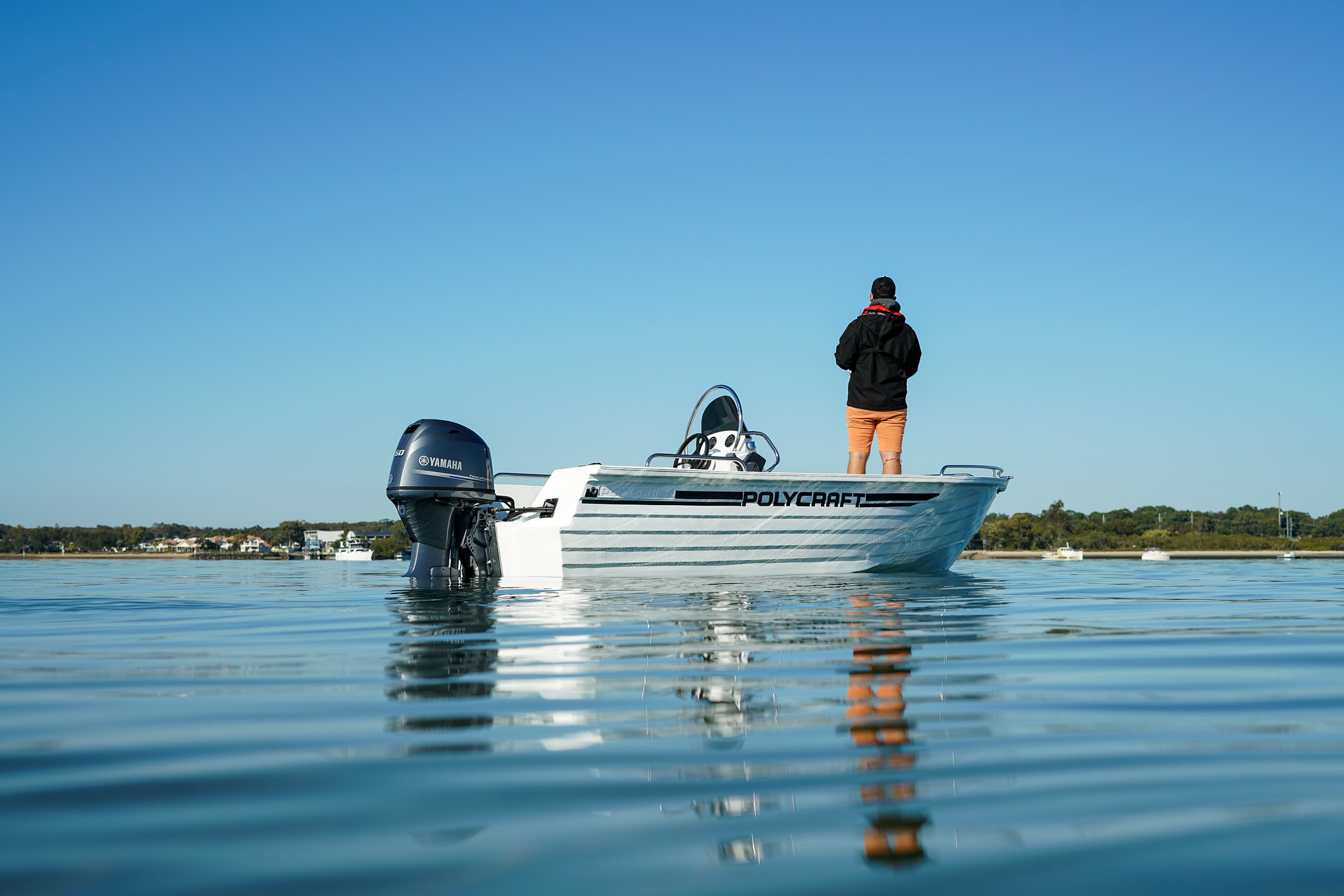 A man standing on a Polycraft boat's deck.