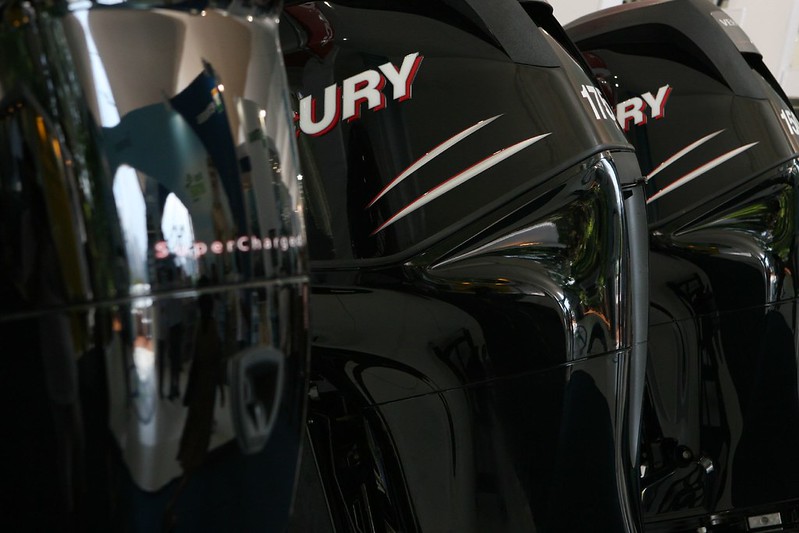 A row of three shiny black Mercury outboard motors.