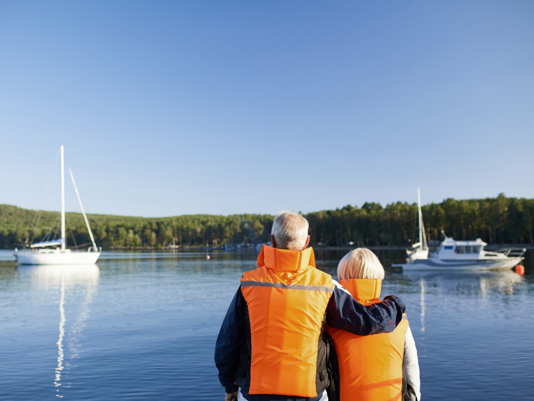 Men wearing a life jacket while fishing at sea.