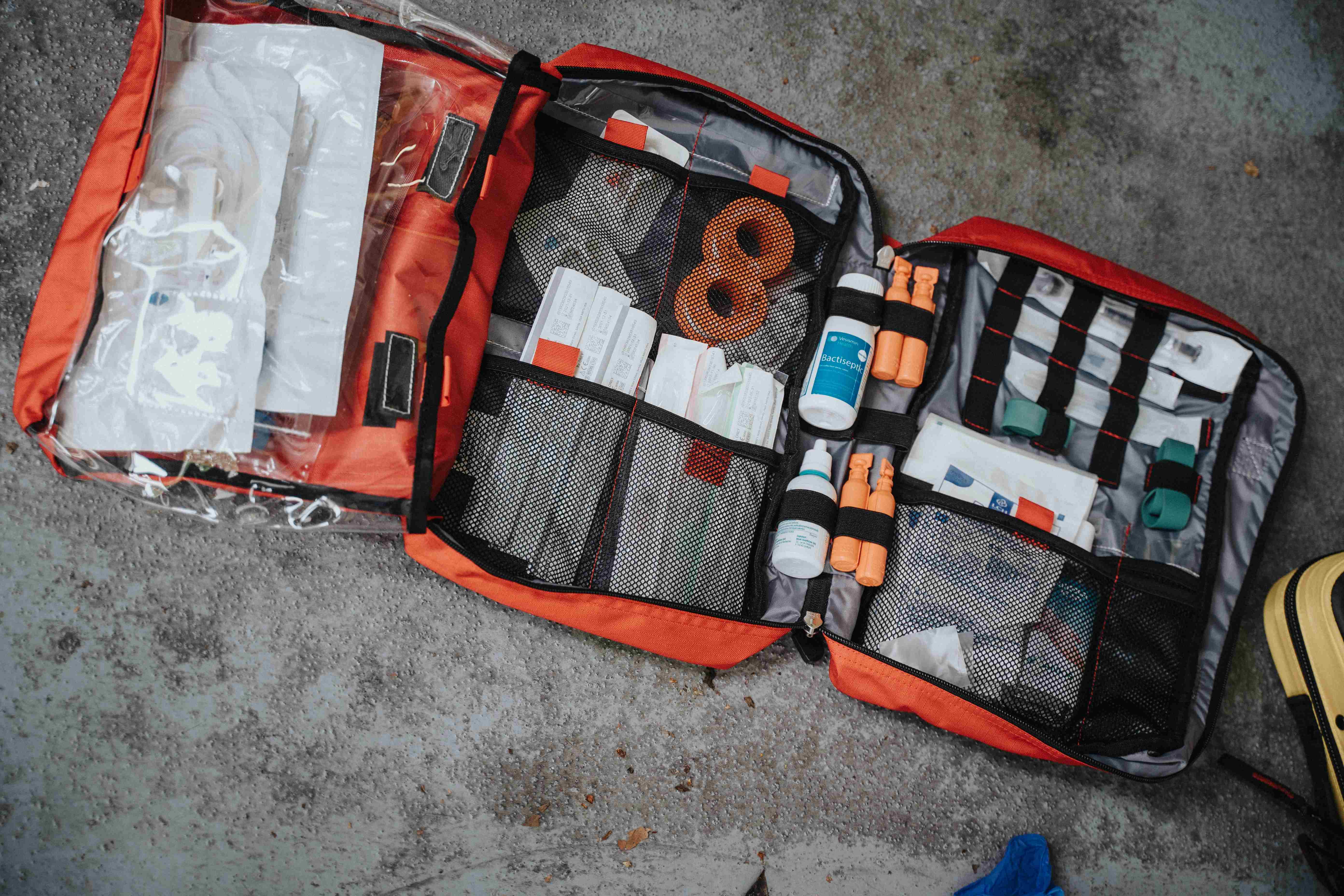 An orange first aid kit laid on a flat surface.