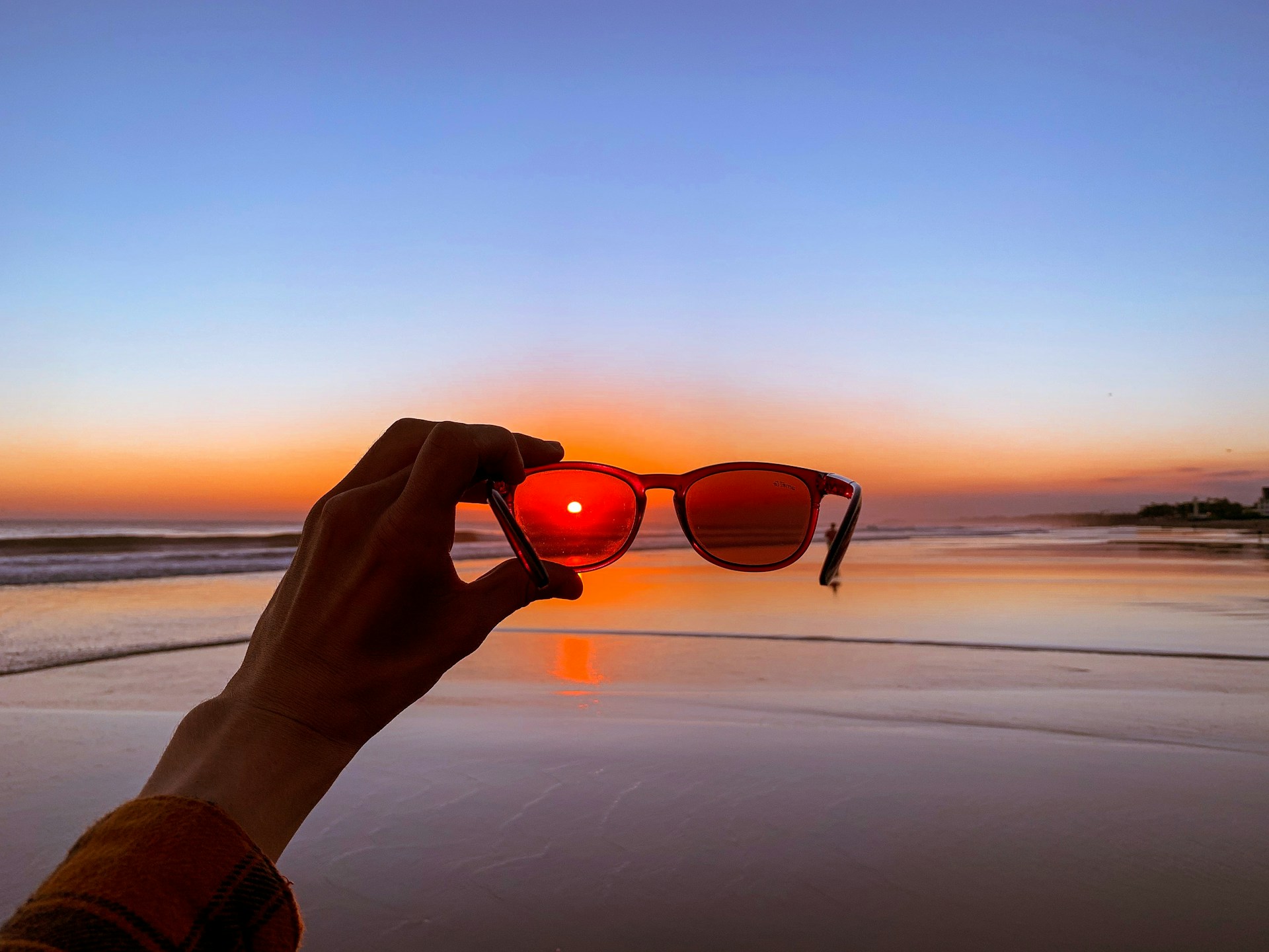 Person holding a pair of sunglasses.