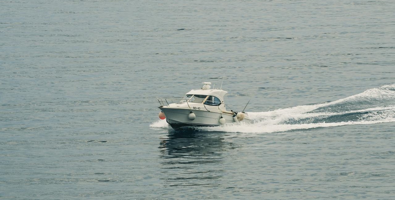 A motorboat with fenders positioned on its hull while its underway.