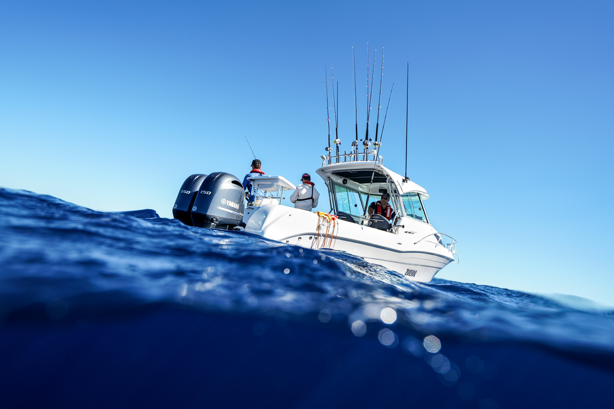 A low shot angle of a fishing boat and anglers on board while being out in the ocean