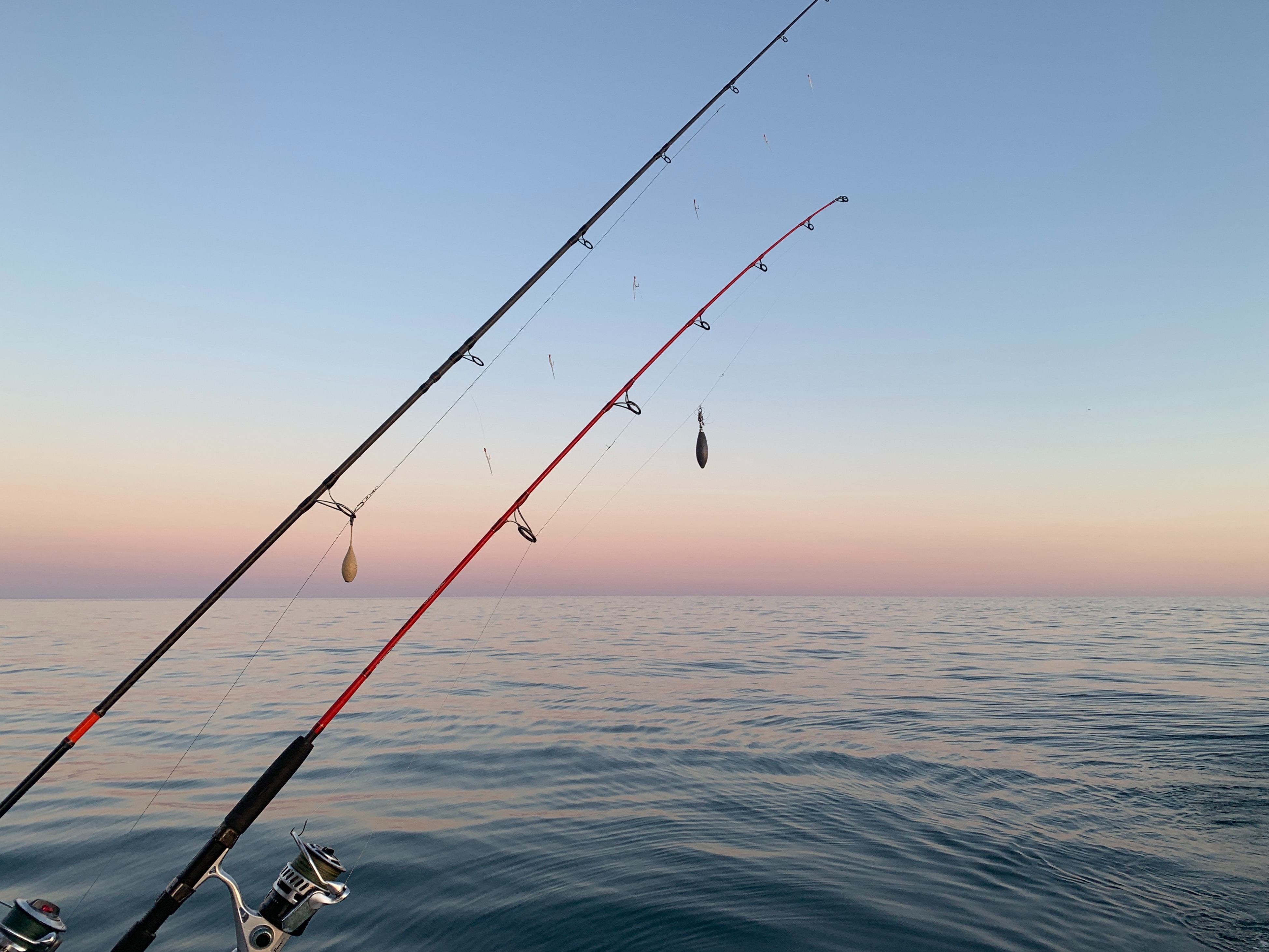 Two fishing rods being cast out in the ocean.