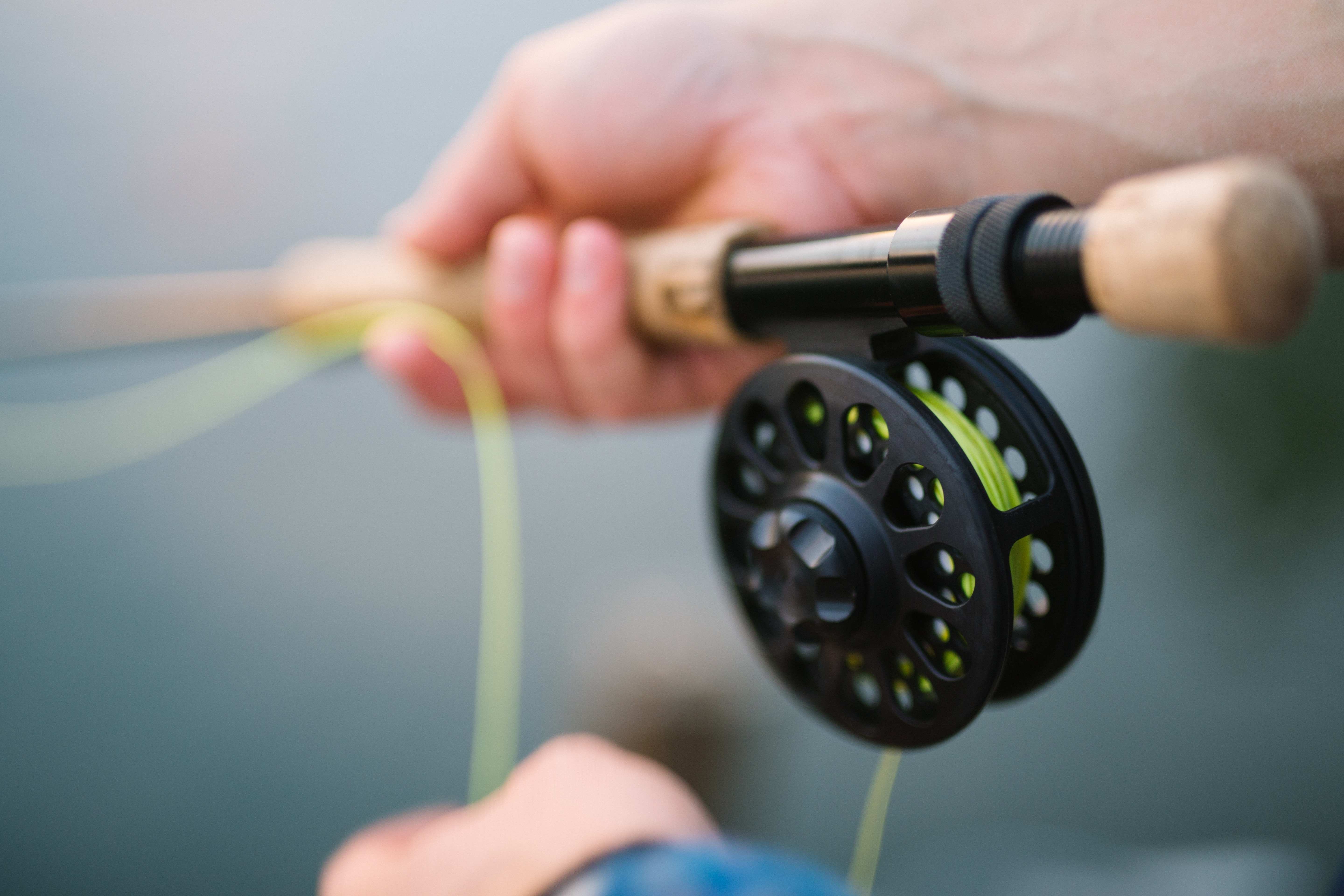 Close up shot of a fishing reel and rod being used.