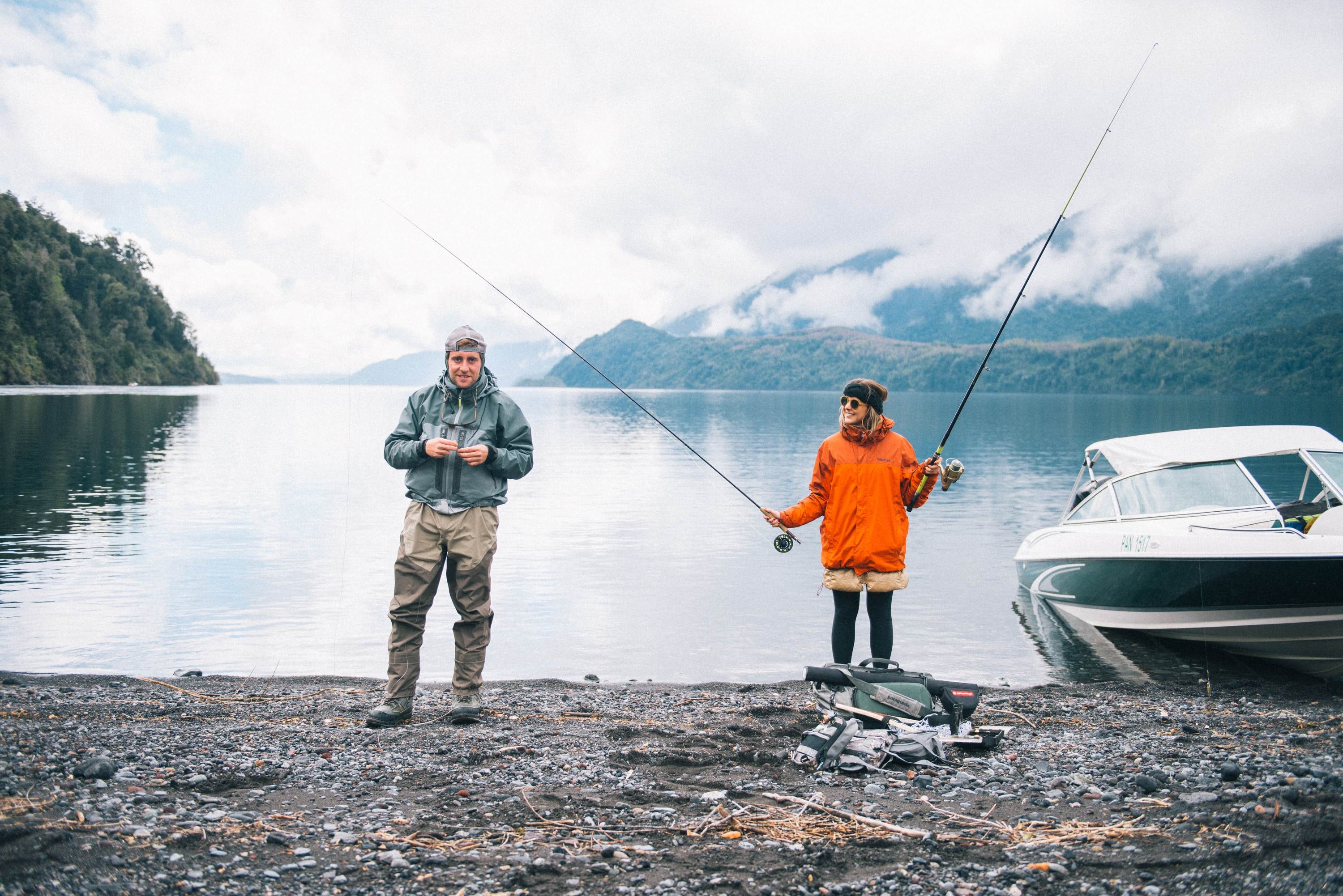 A pair of anglers standing on a river bank.