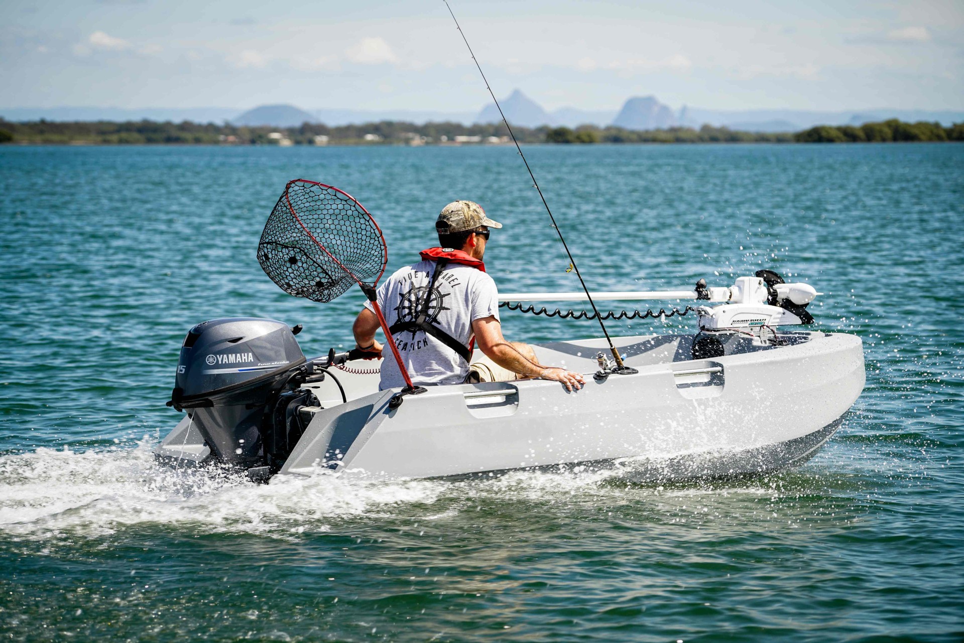 A man operating a small open fishing boat.