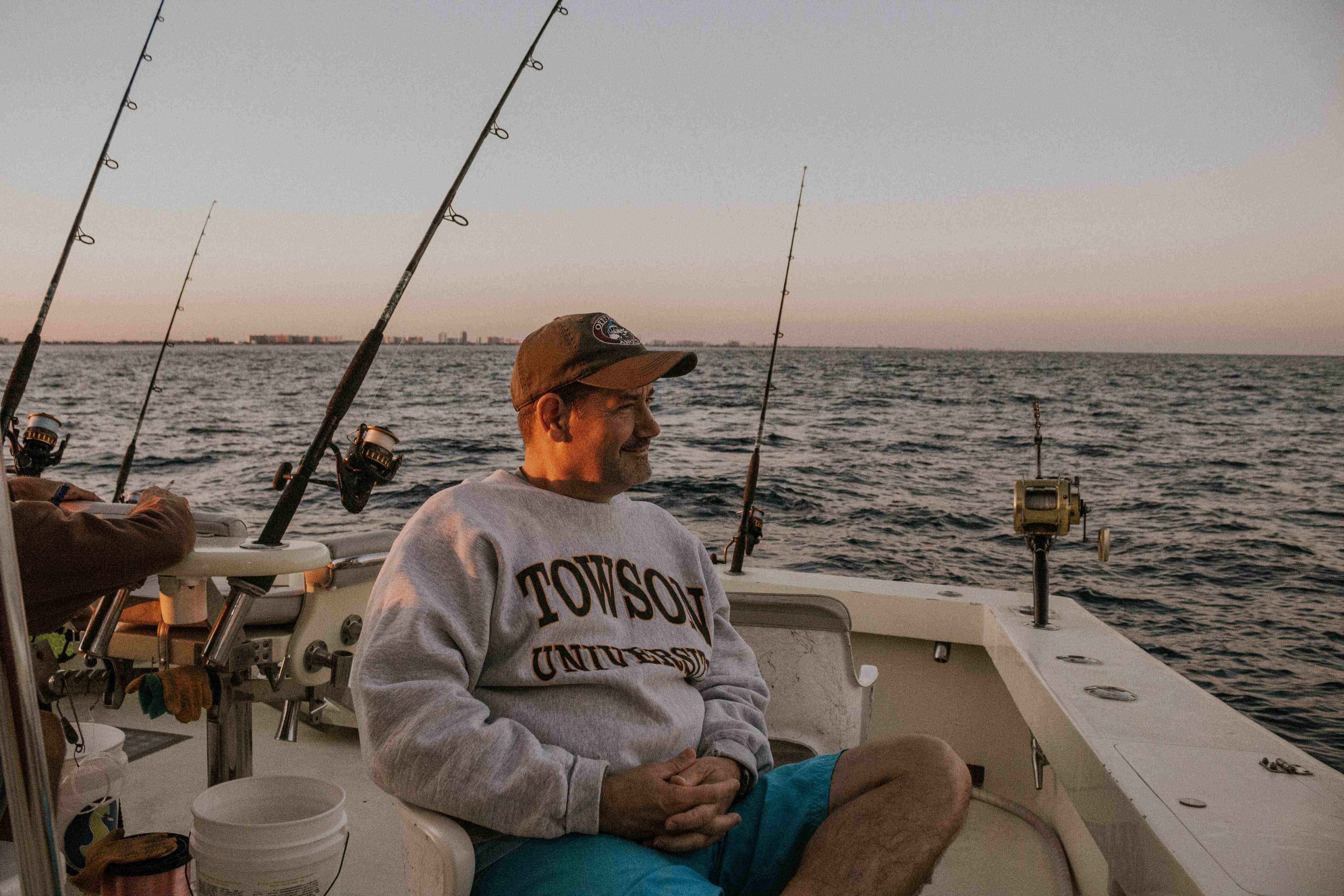 A fisherman sitting contently on a fishing boat.