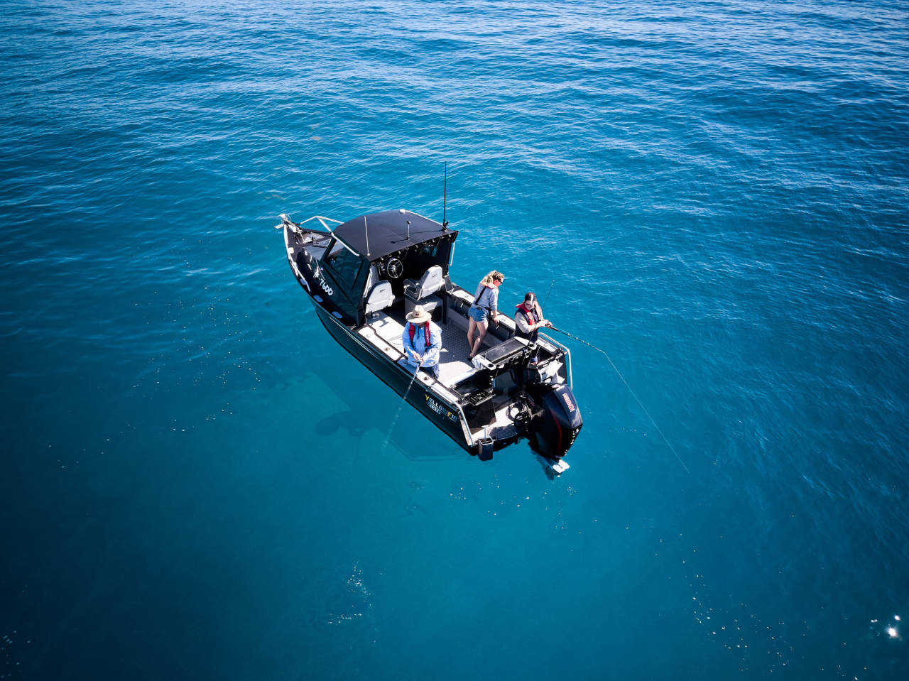 A high angle shot of a group of anglers fishing on a fishing boat.