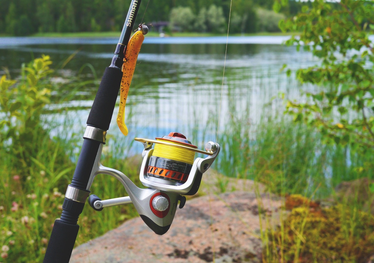 A close up of a fishing reel with a lure attached.