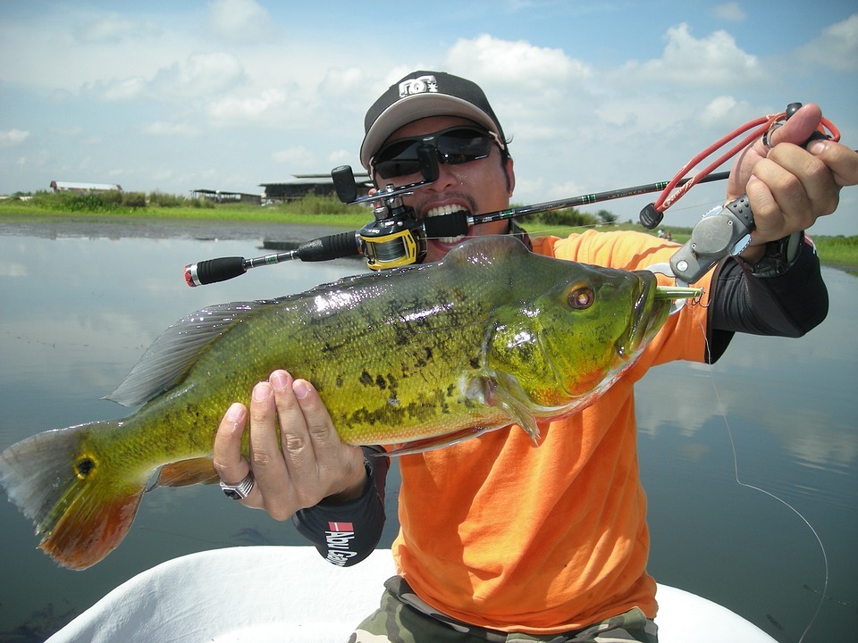 An angler proudly presenting a bass he caught.