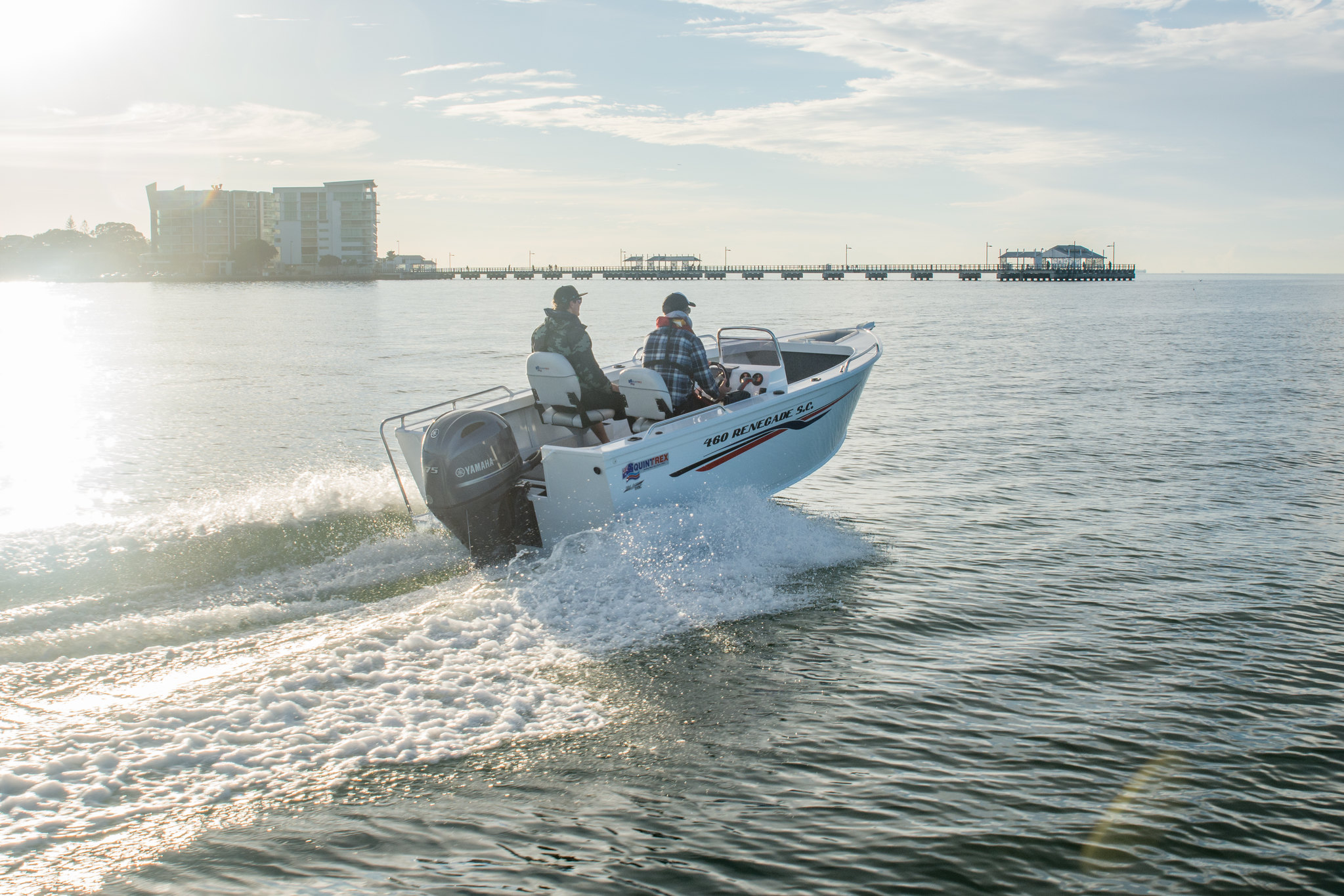 Two men aboard a Quintrex open boat while it's moving at sea.