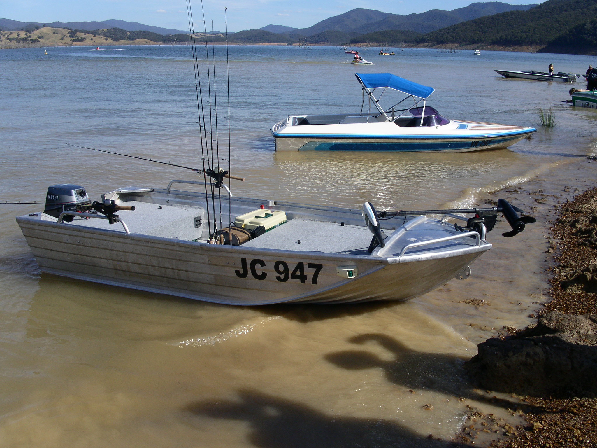 An aluminium boat beached at shore.