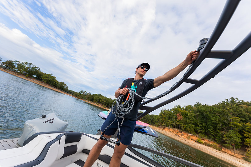 A man on a boat holding a tow rope.