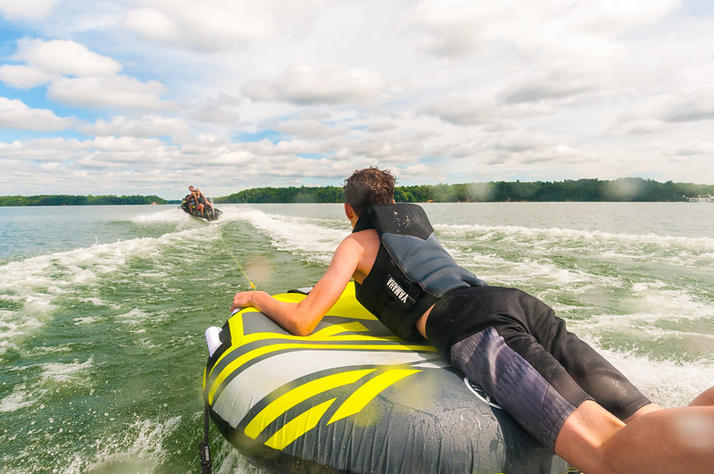 A kid on a tube being pulled behind a boat.