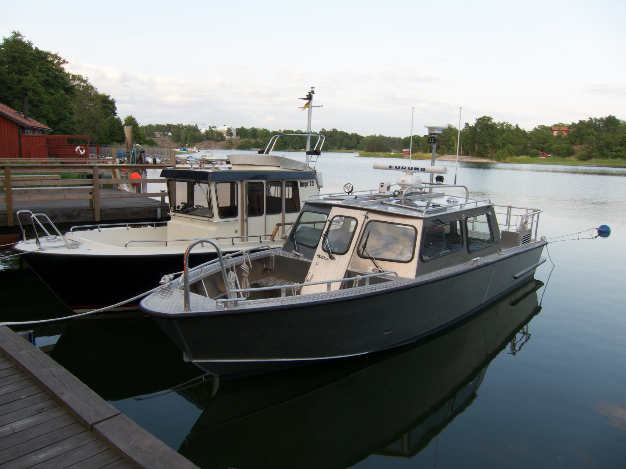 An aluminium boat docked at a docking area.