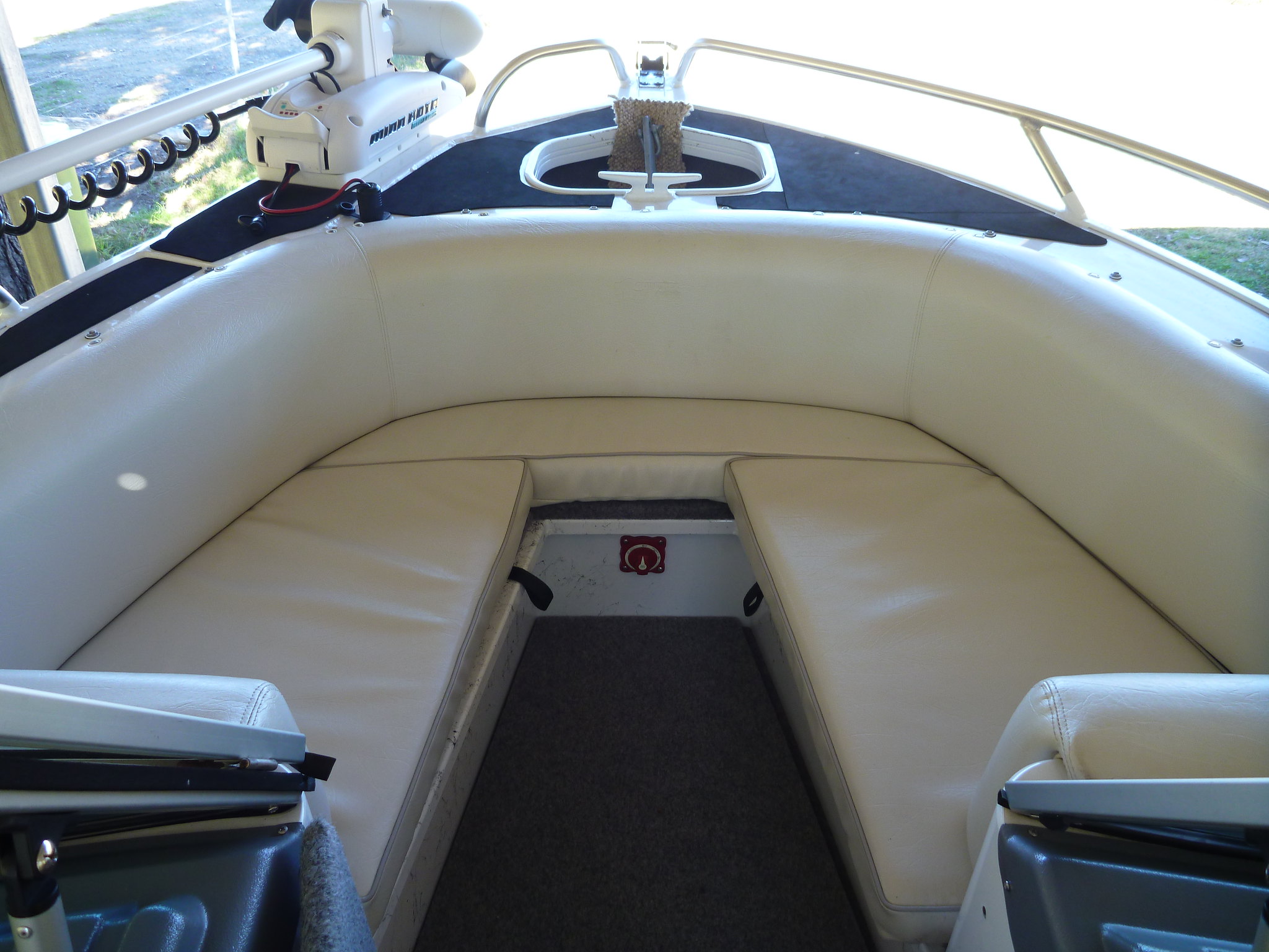 View of a boat's bow with upholstered seats.