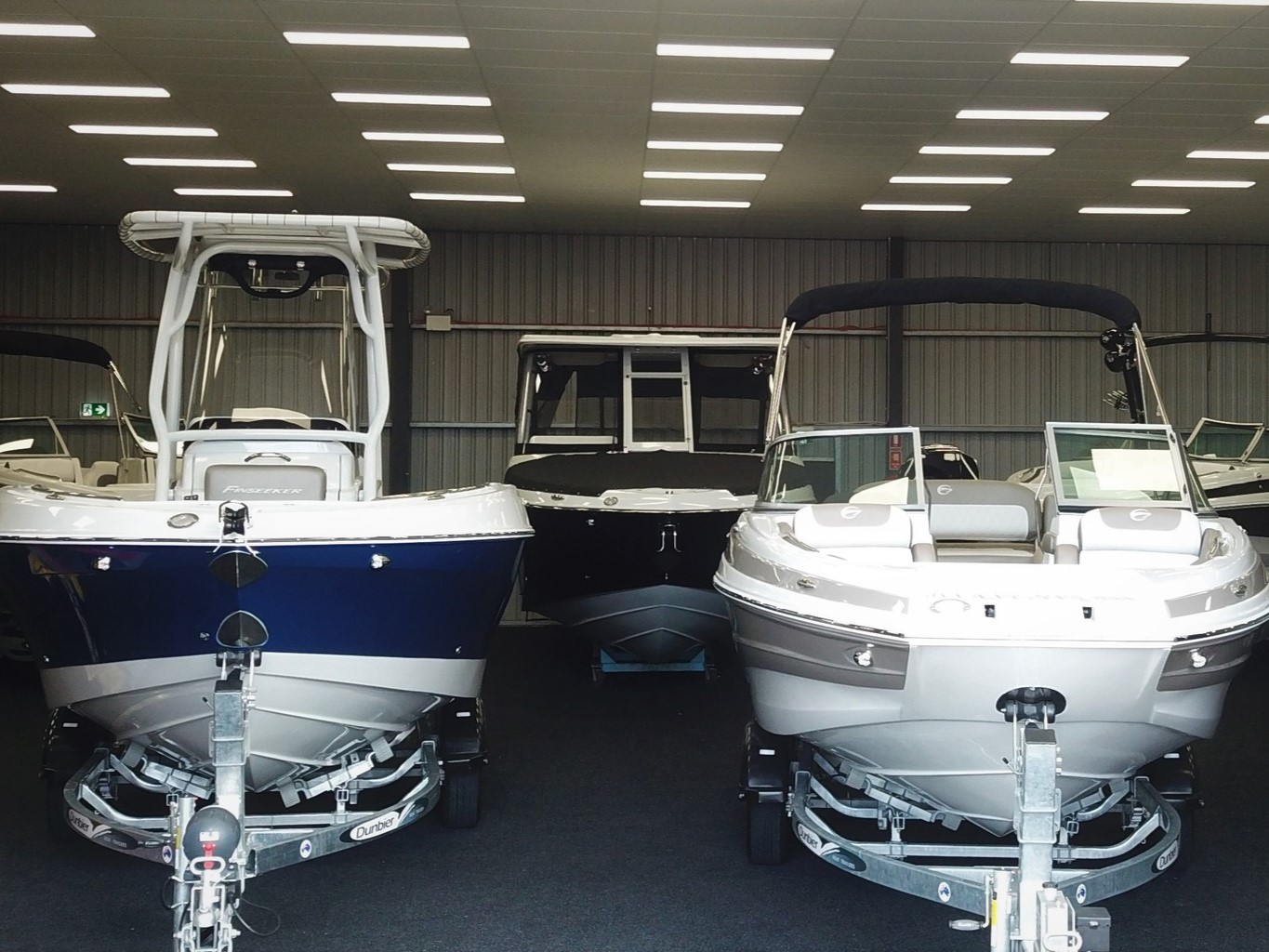A row of Crowline boats displayed in a showroom.