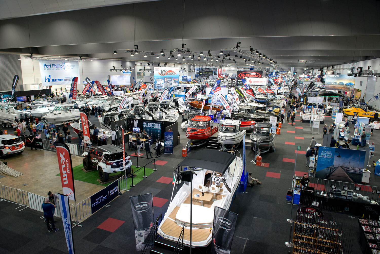 A high angle shot of a wide display of boats from various brands in a boat show.