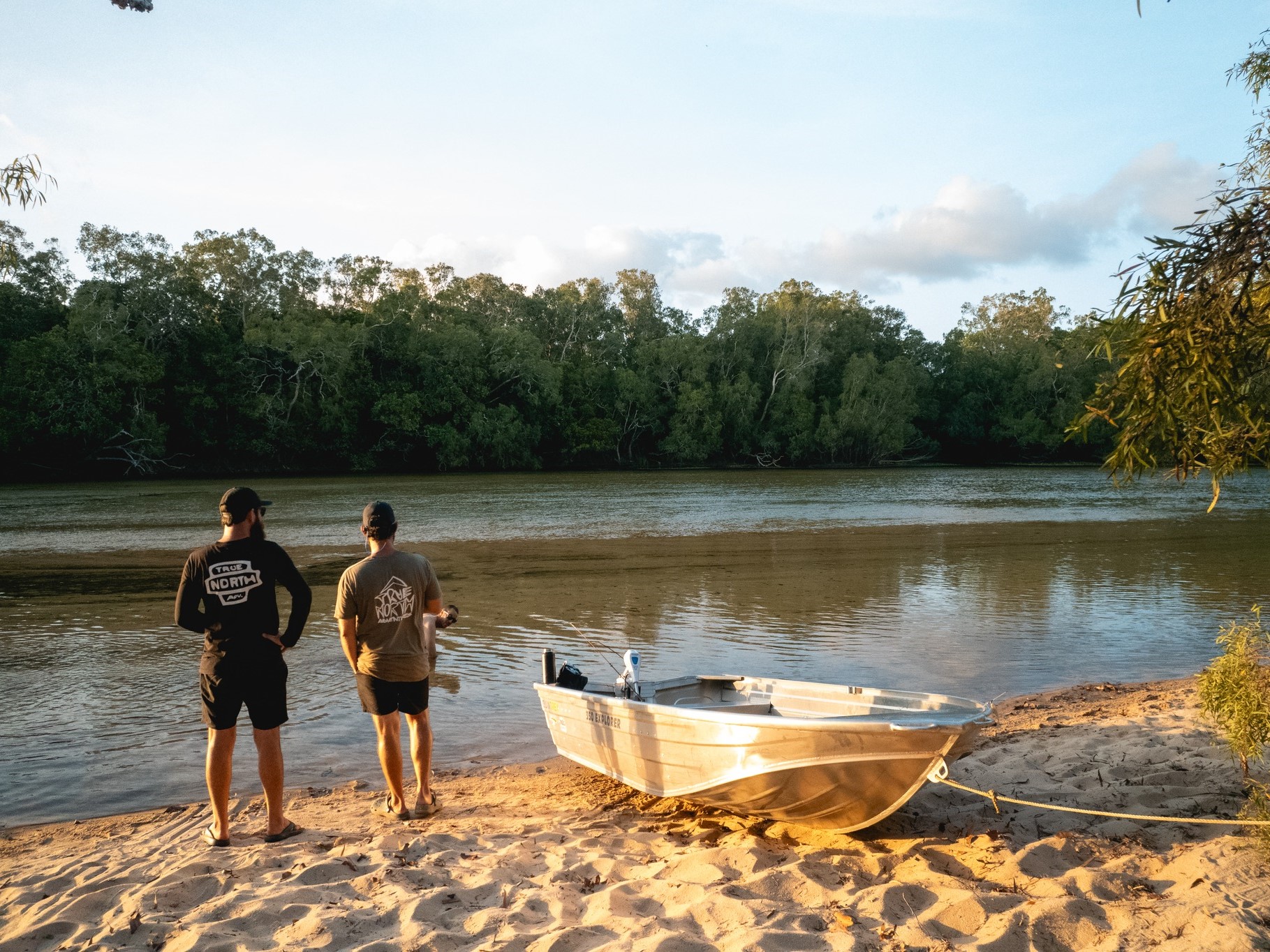 Two men and a Quintrex tinnie boat on the shore.