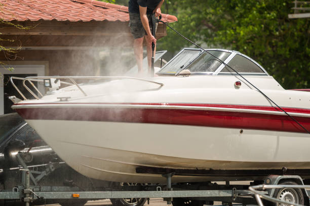 A man cleaning a boat with a pressure washer