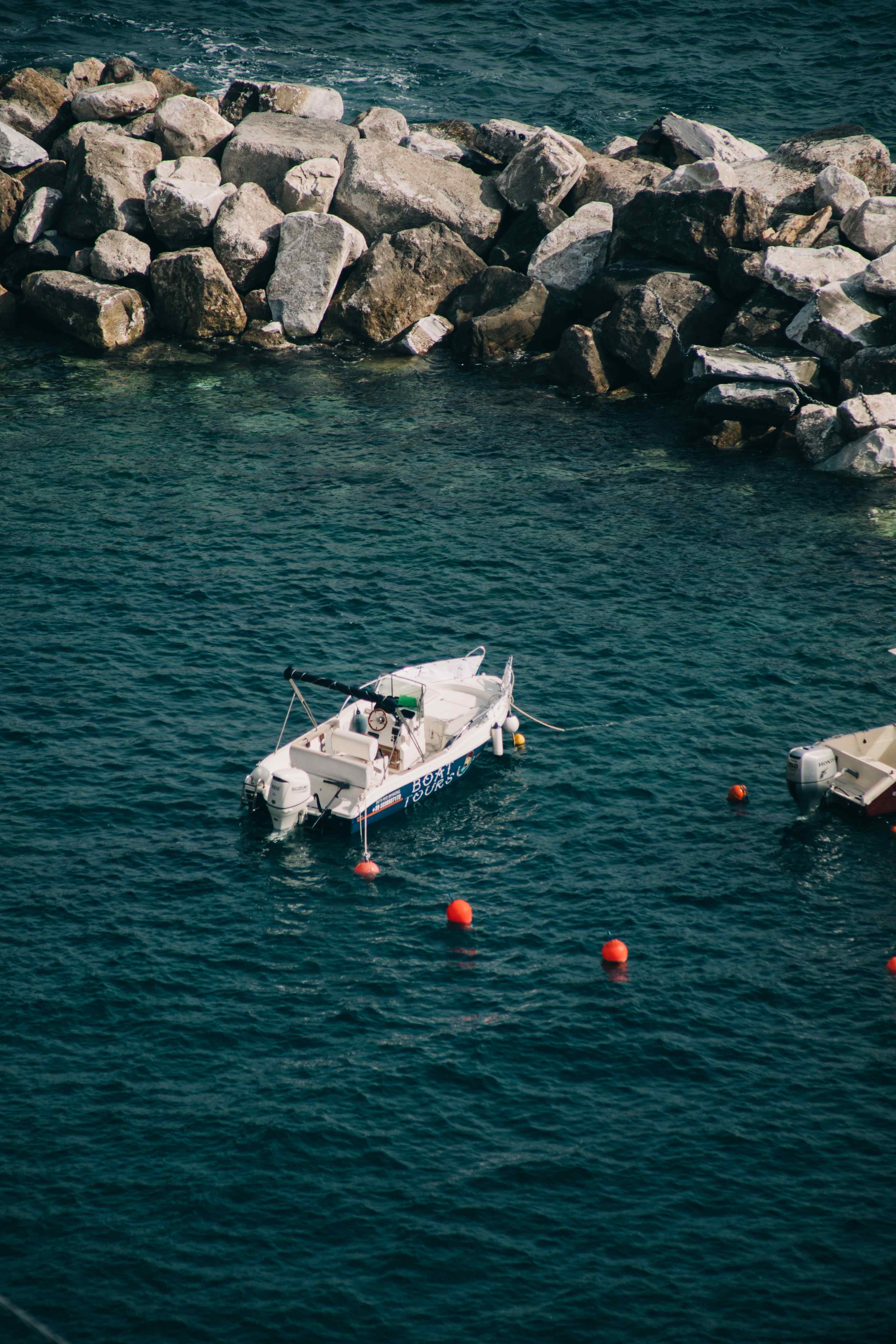 A boat anchored near a rocky shore.