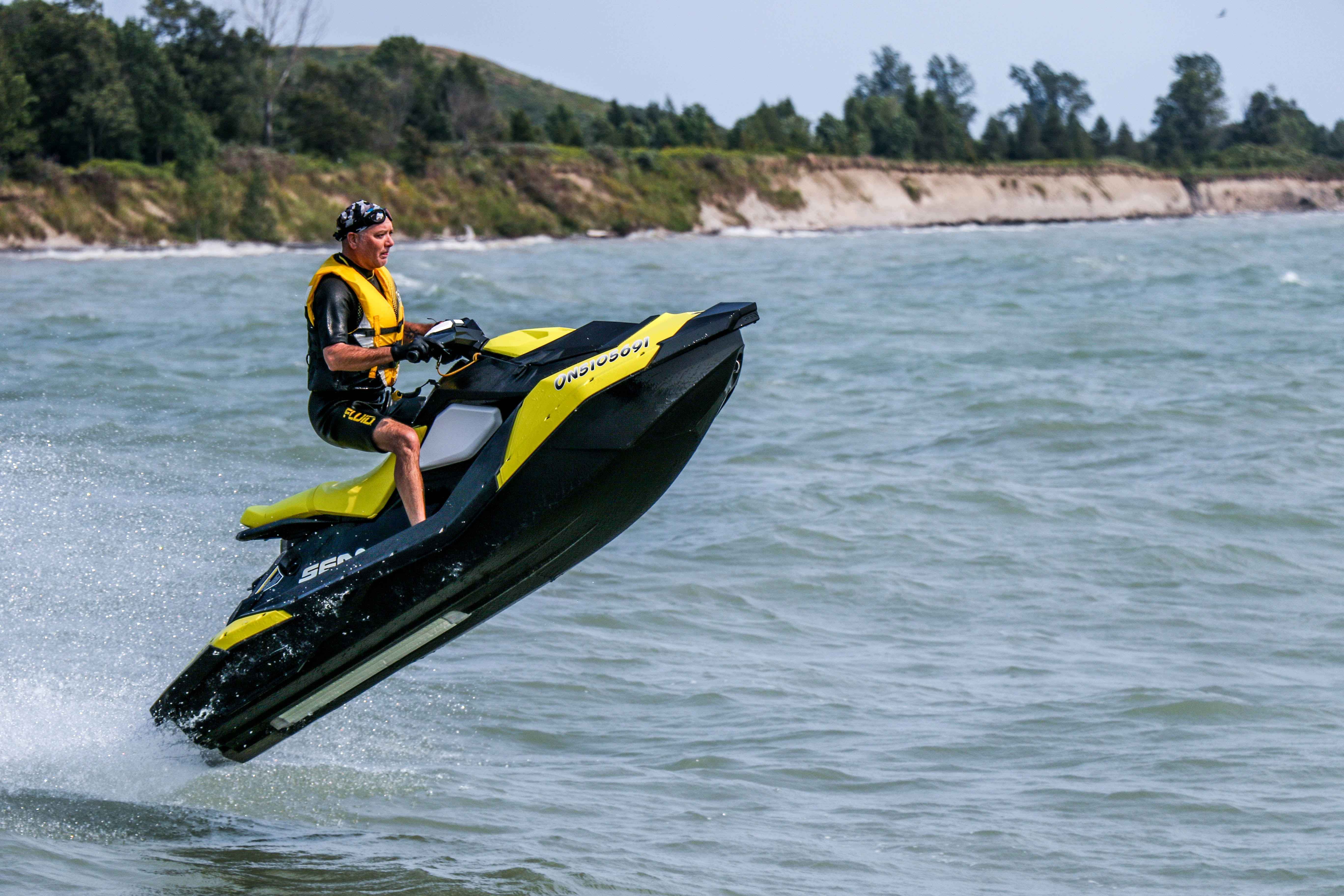 A man riding on a yellow jet ski.