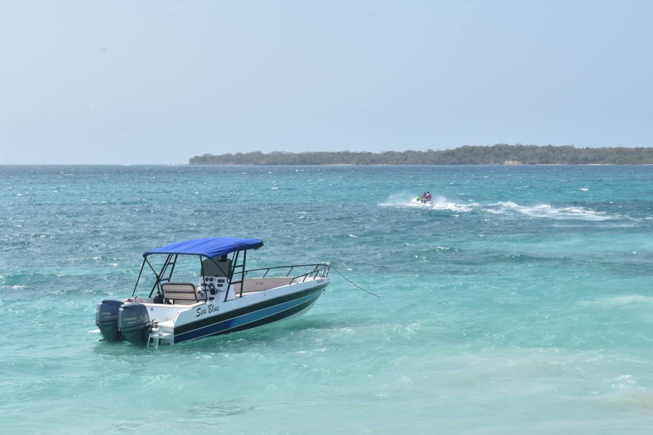 A centre console boat anchored near shore.