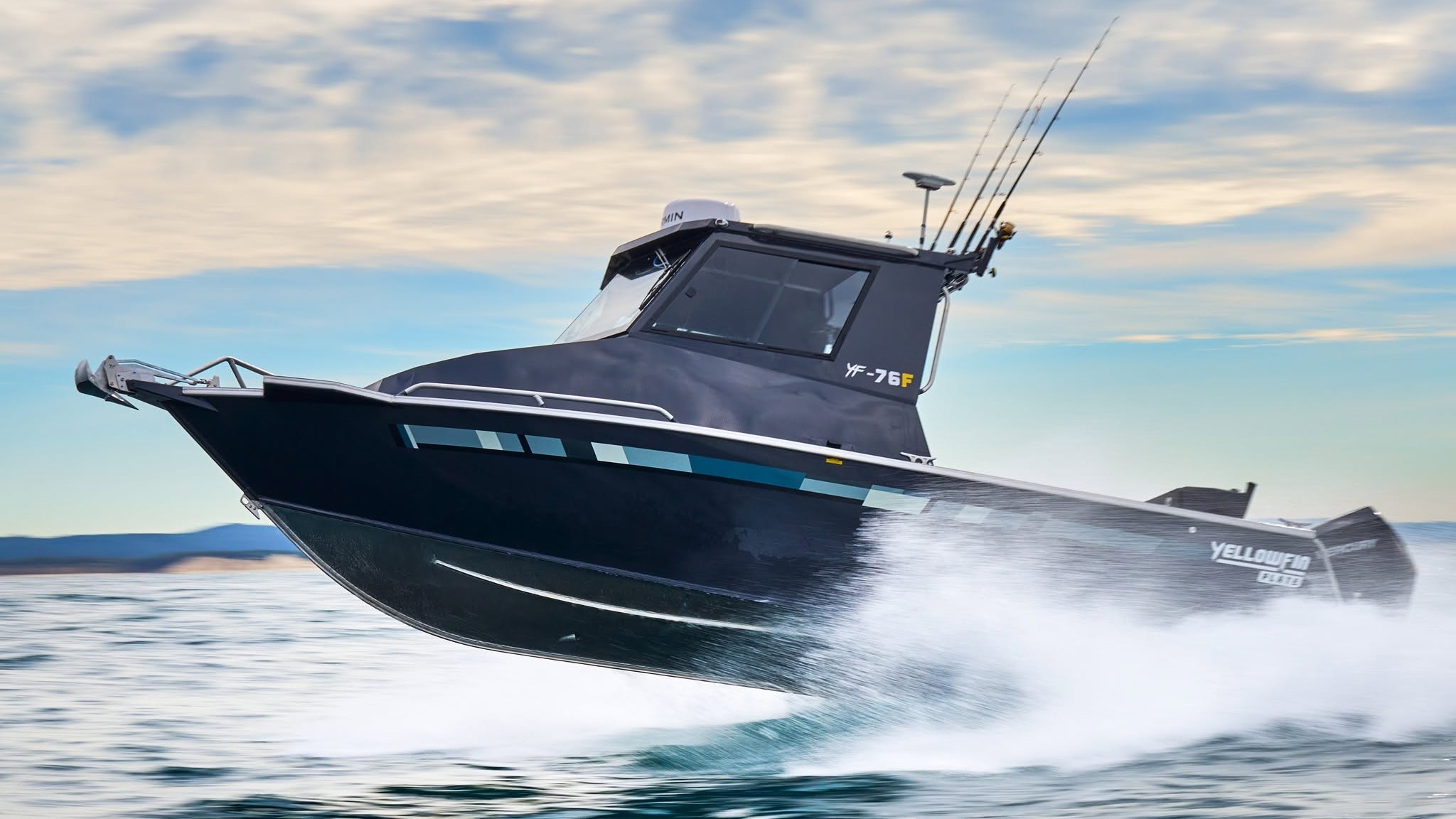 yellowfin hard top boat planing on the water