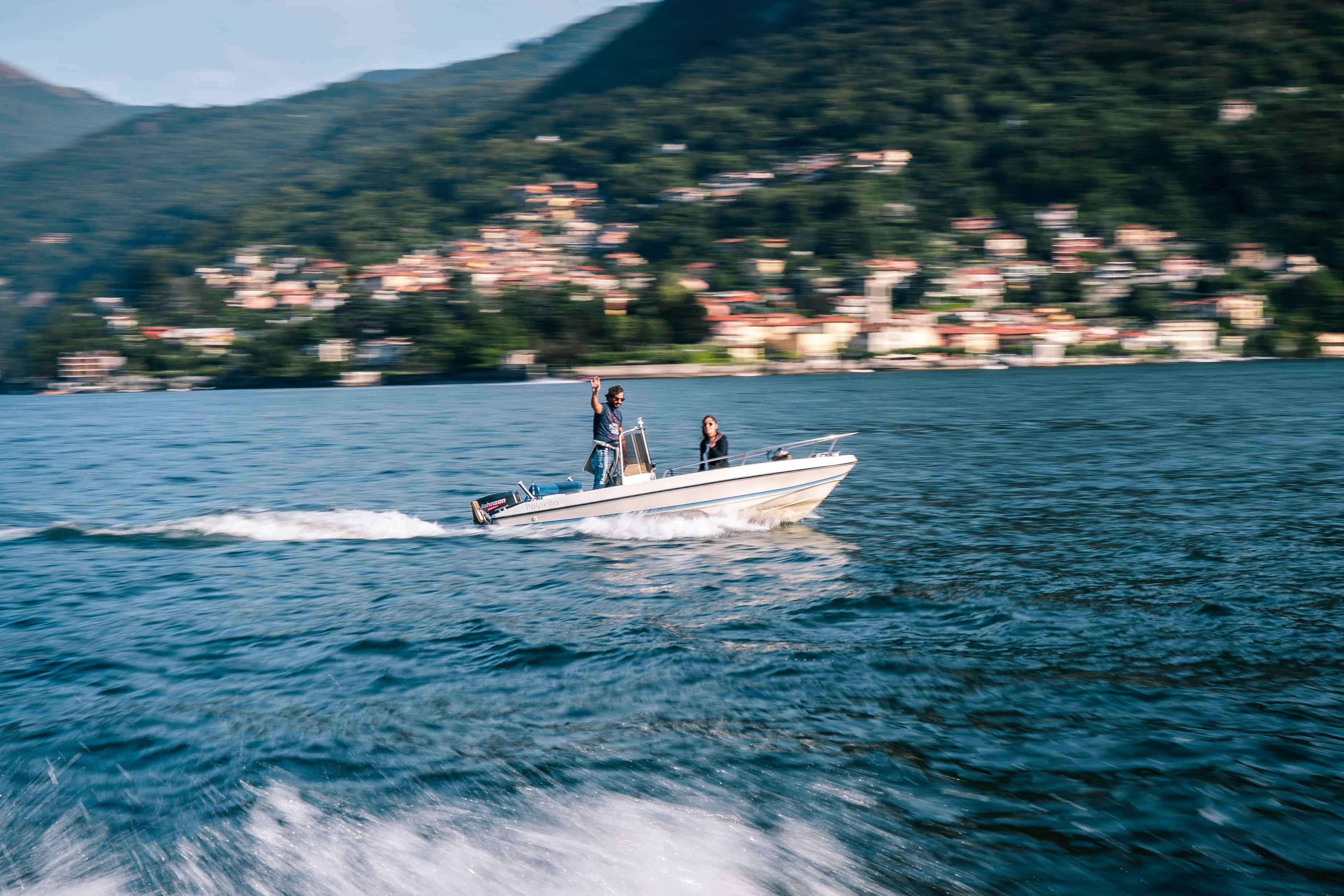 A man and a woman onboard a boat that is underway.