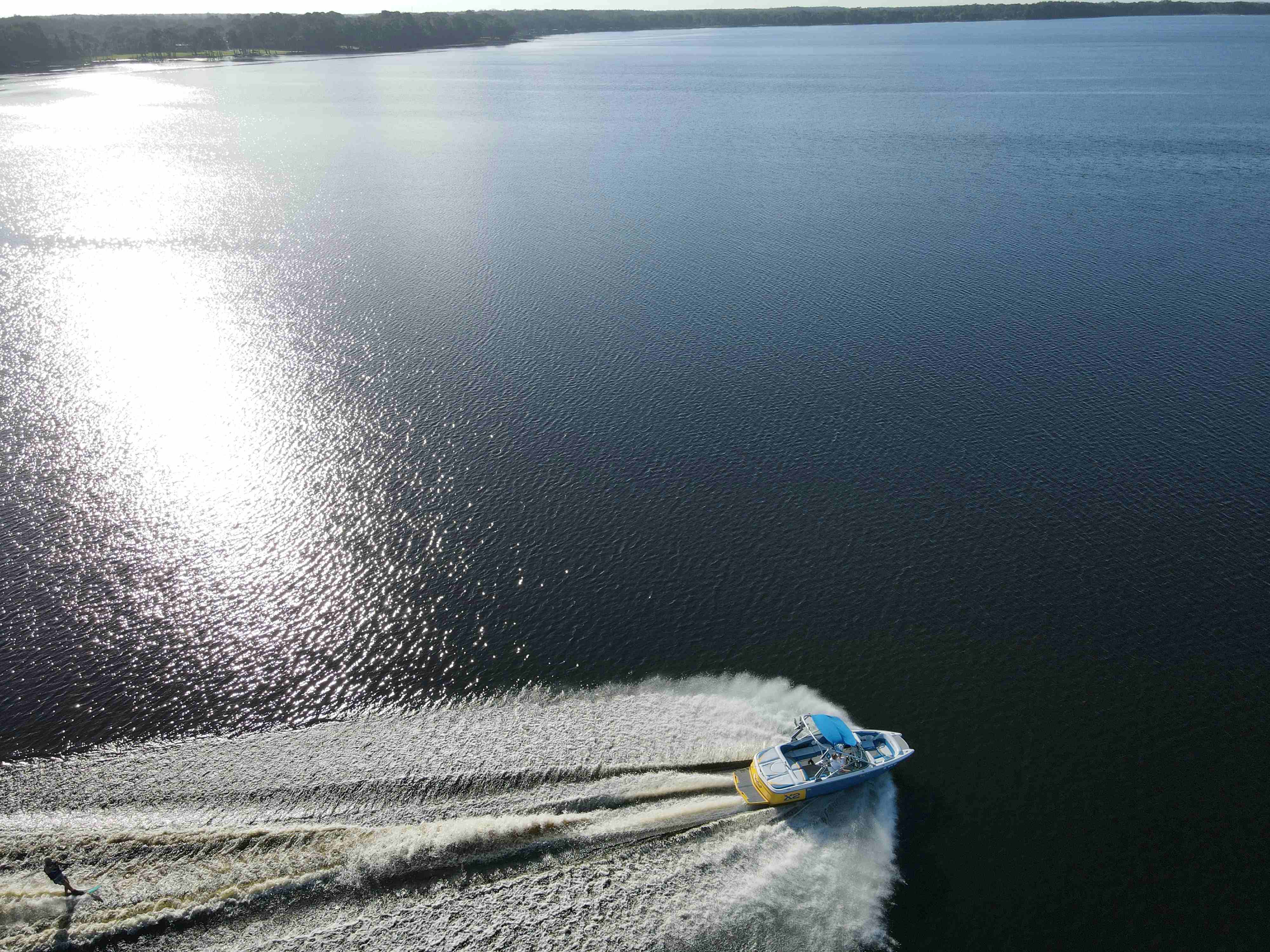 A bird's eye view of a boat travelling fast at sea.