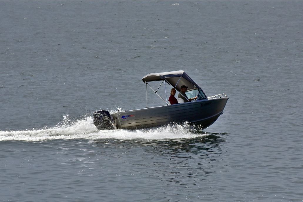 A wide angle shot of two people onboard a plate boat.