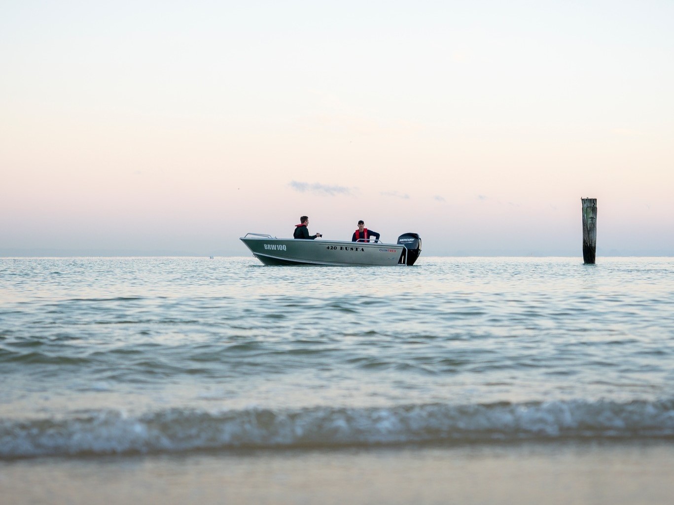 quintrex busta boat in shallow water near shore
