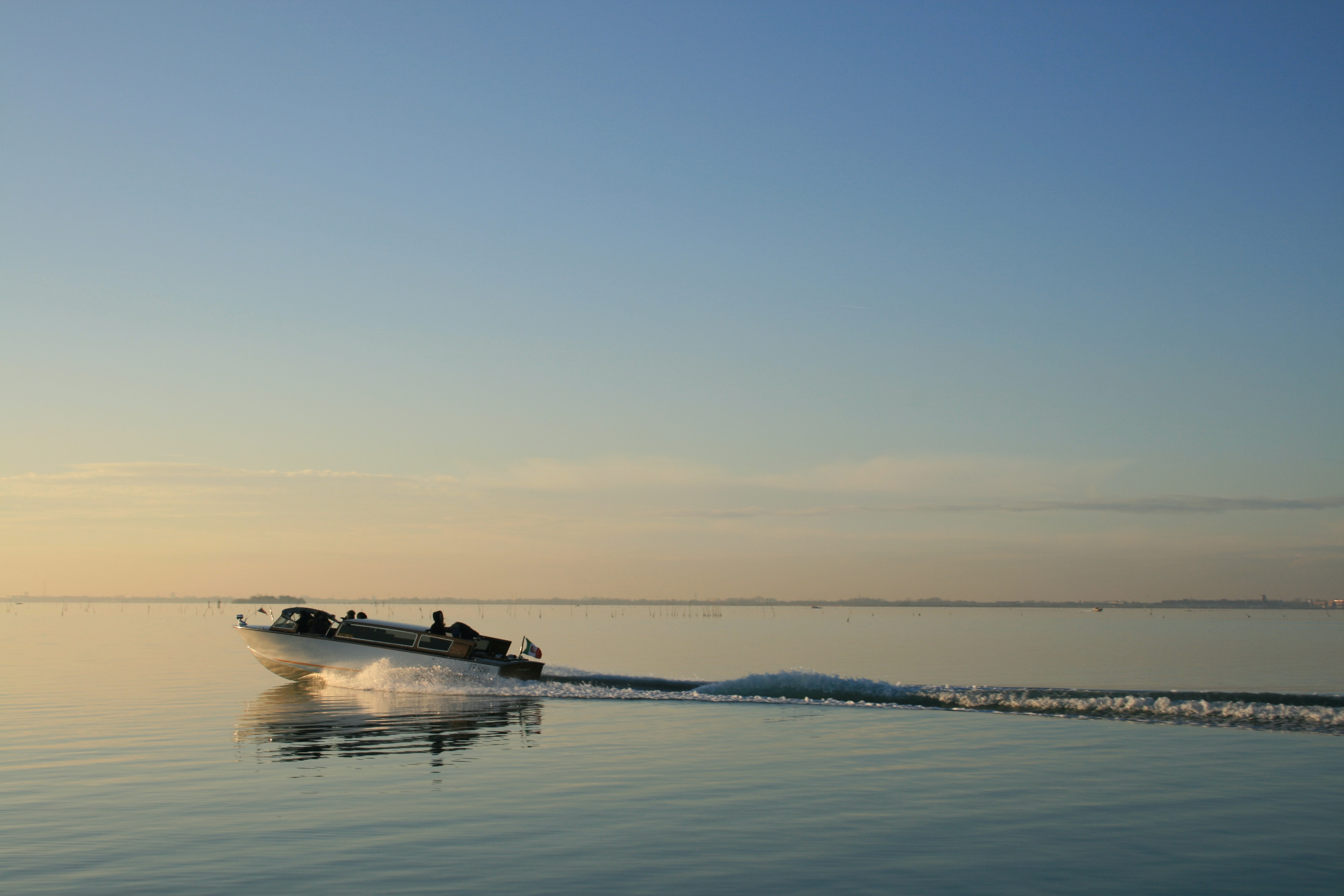 A small boat gliding on a calm sea water.