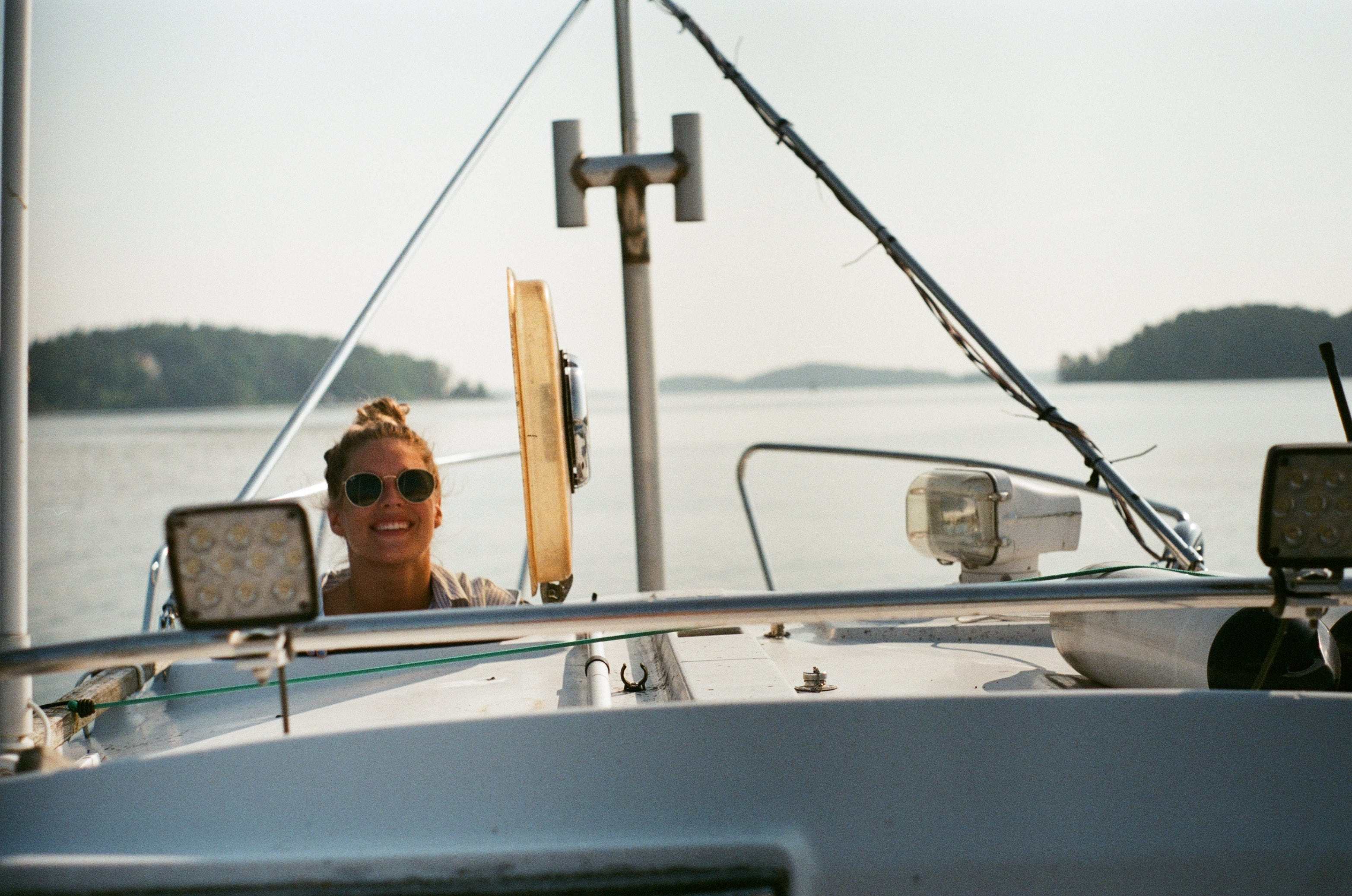 A woman operating a white boat.